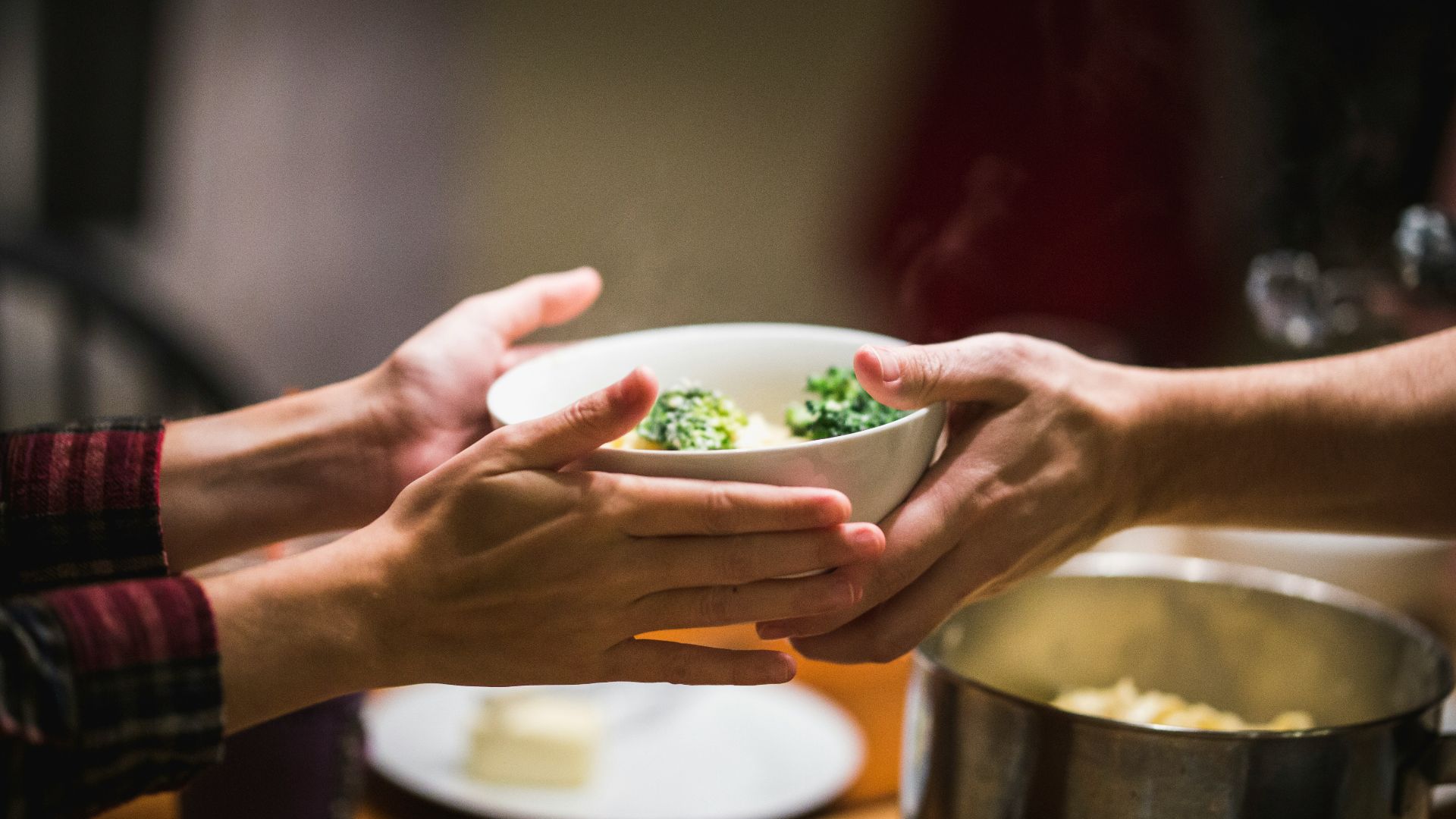 a couple of people holding a bowl of food