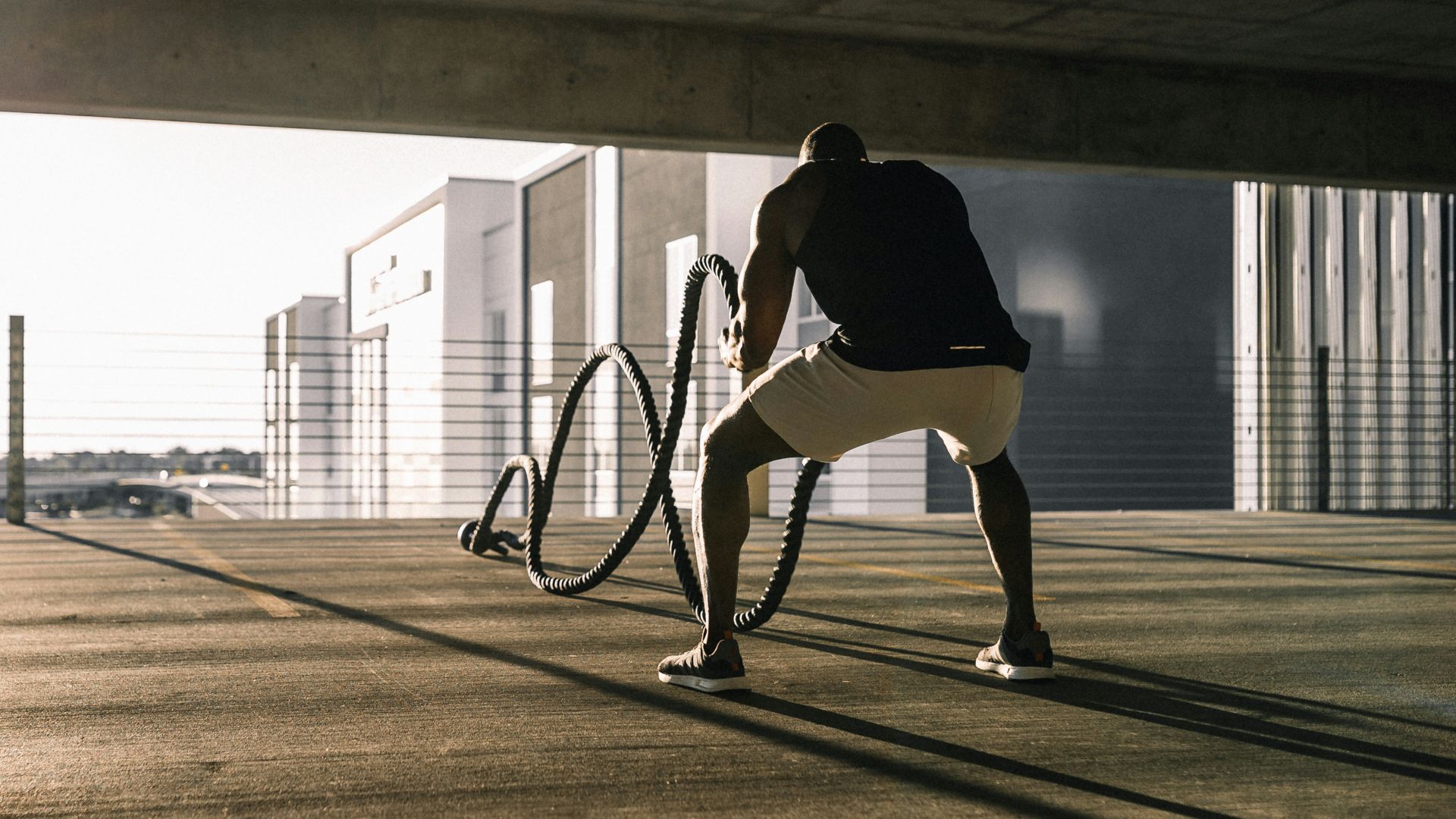 man in black t-shirt and white shorts walking on brown wooden floor