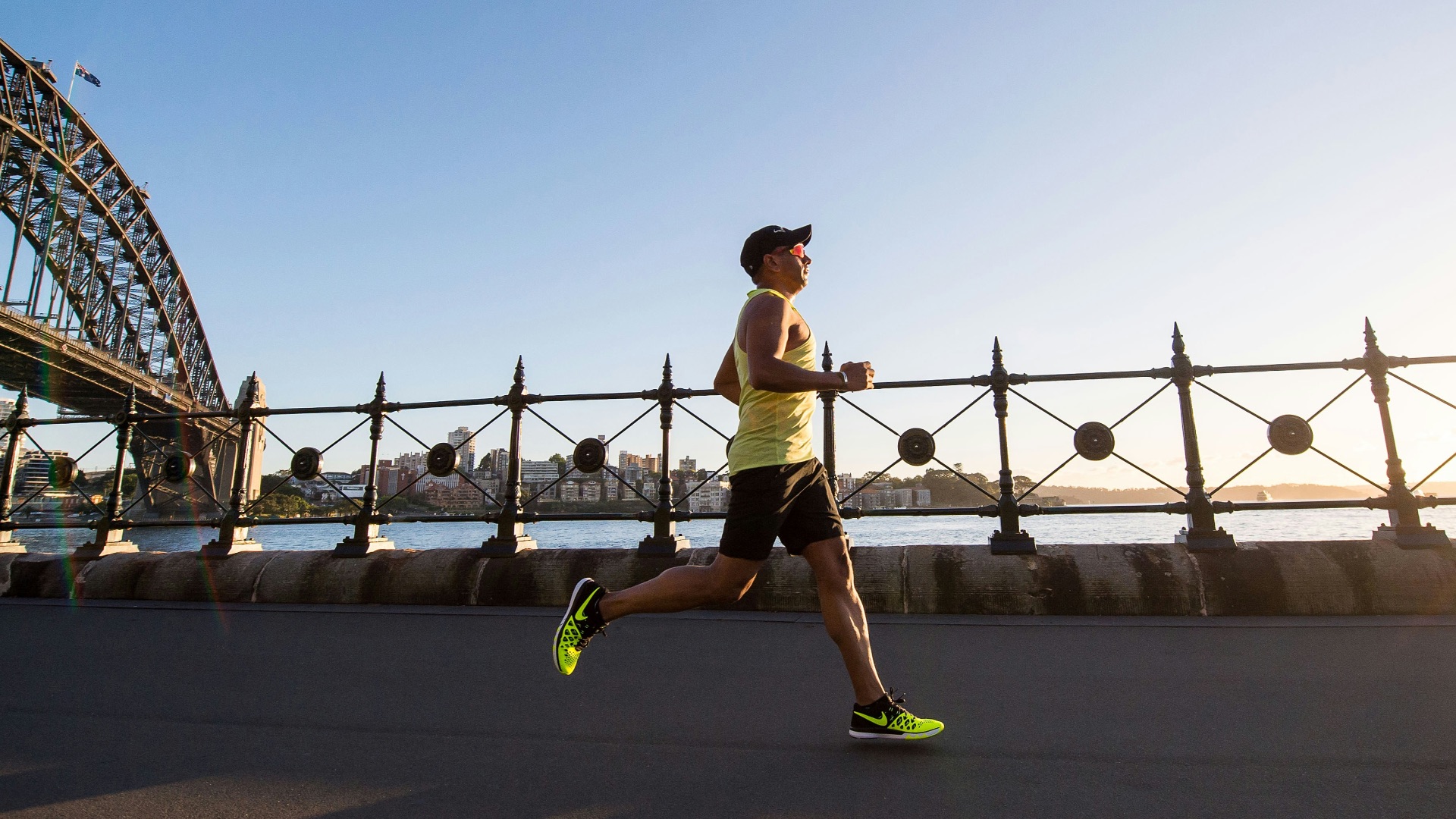 man in yellow tank top running near shore