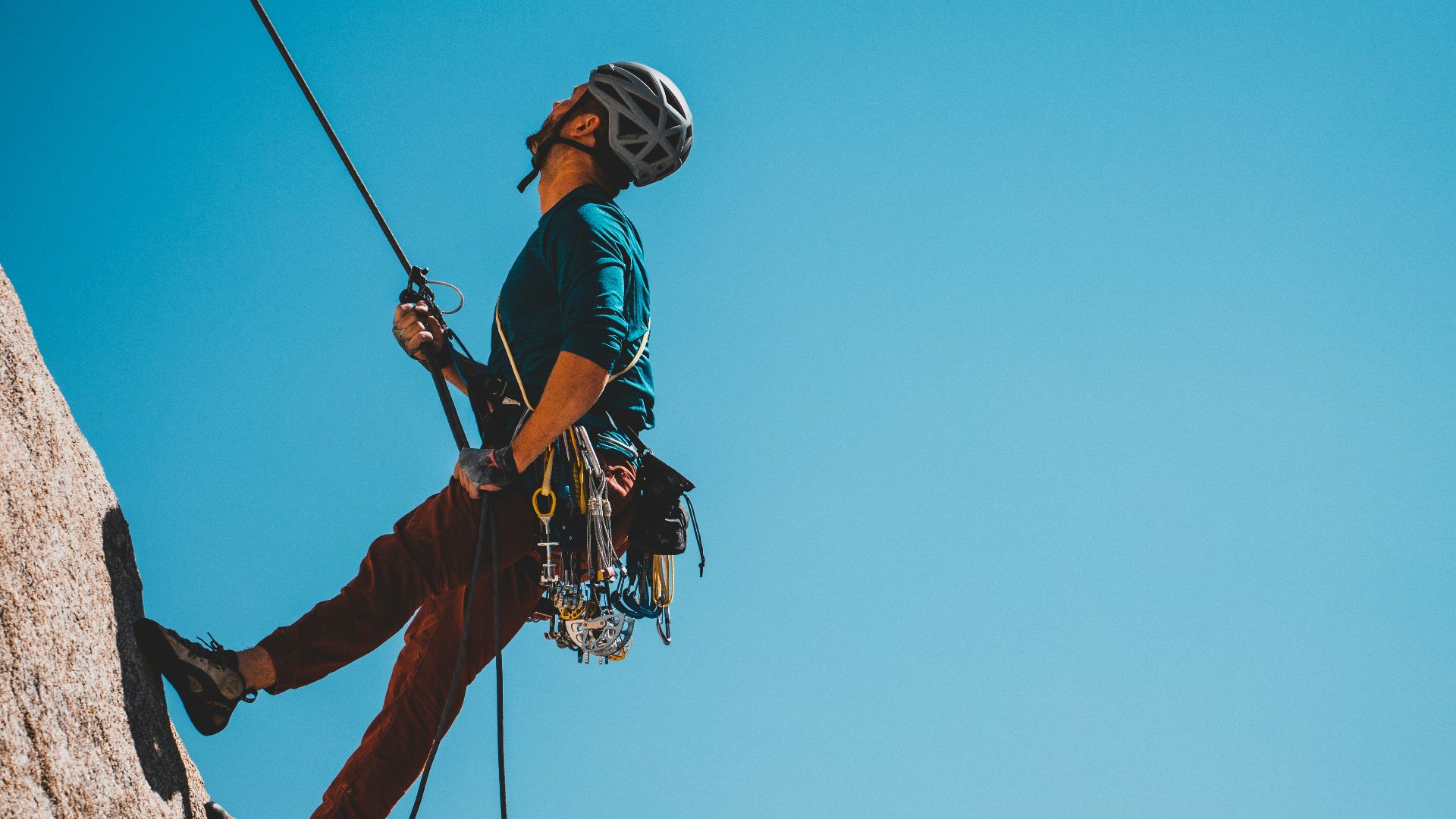 man in blue and orange jacket and black helmet riding on black and white ski lift
