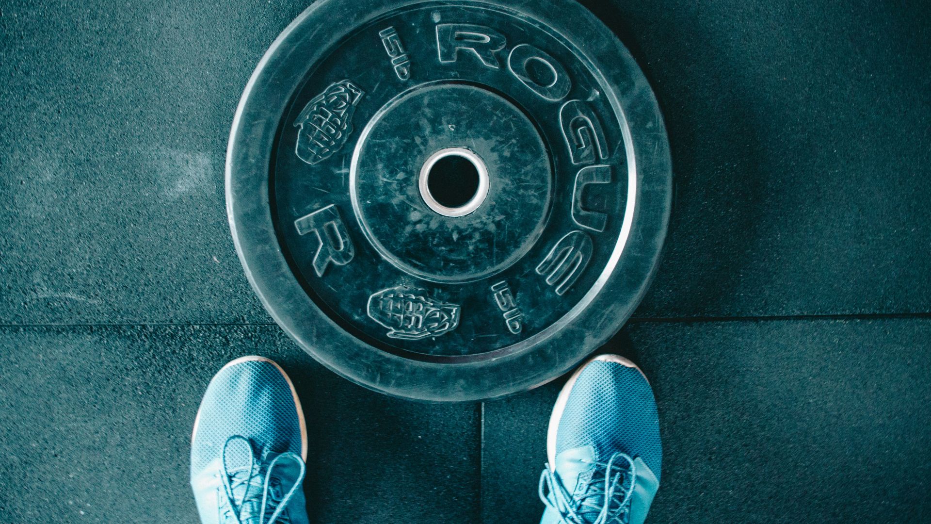 person standing beside black weights
