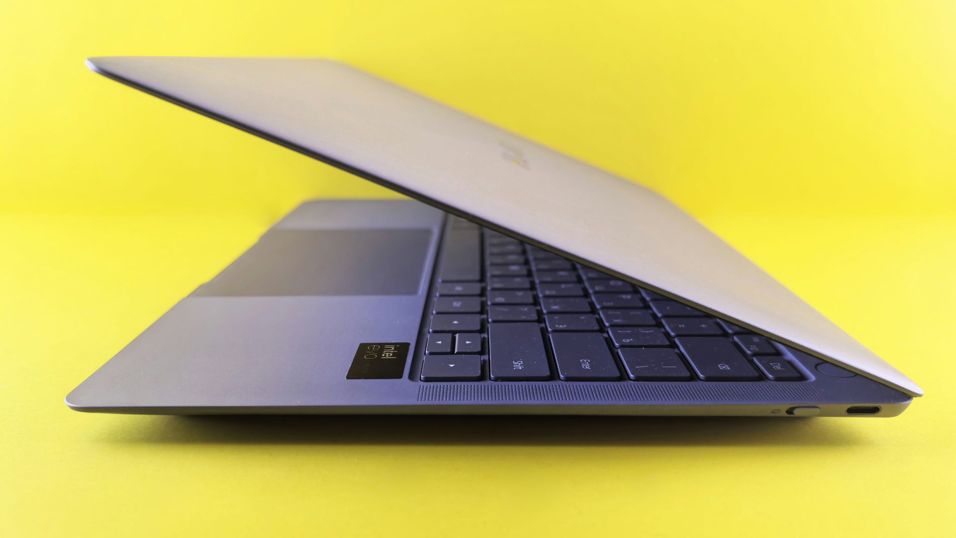Silver laptop computer angled on yellow background