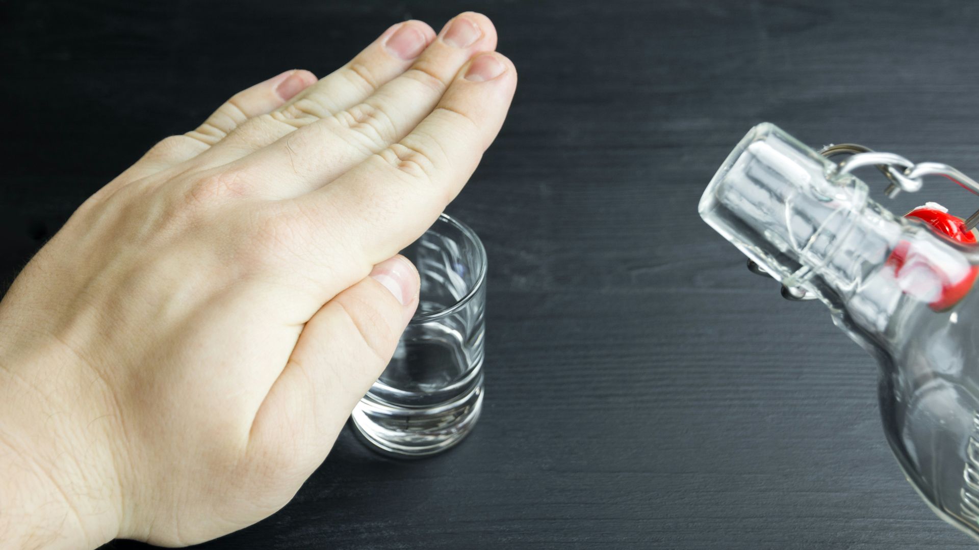 a hand reaching for a glass of water
