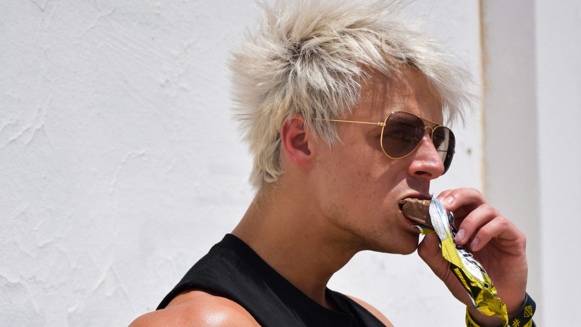 a man with white hair is drinking a drink