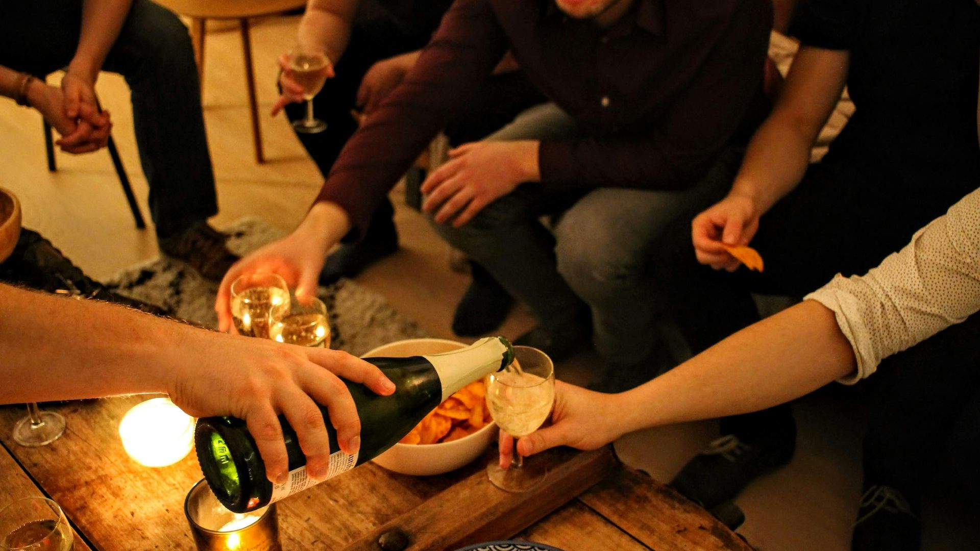 person holding green glass bottle