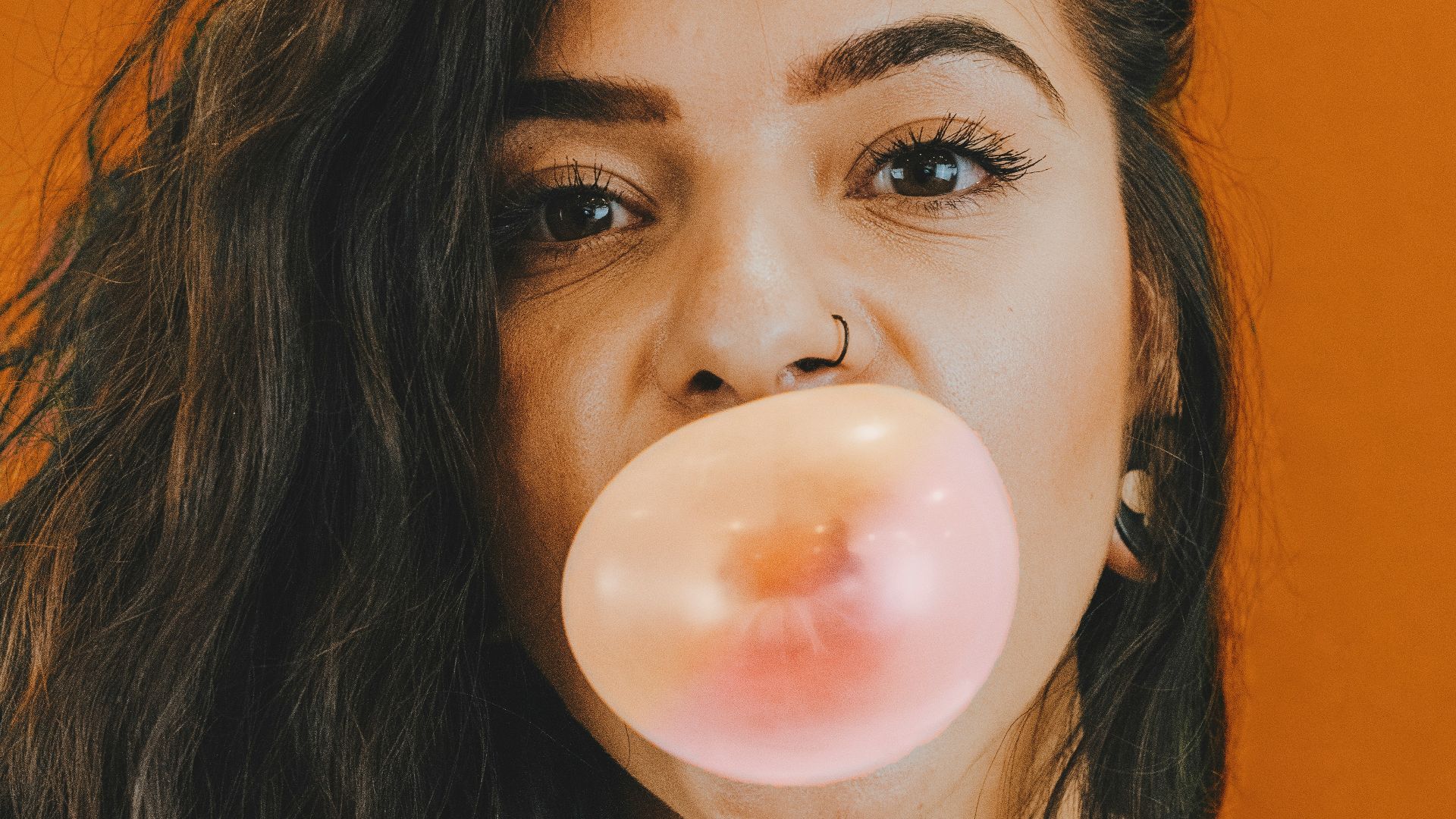 woman in white crew neck shirt blowing bubble