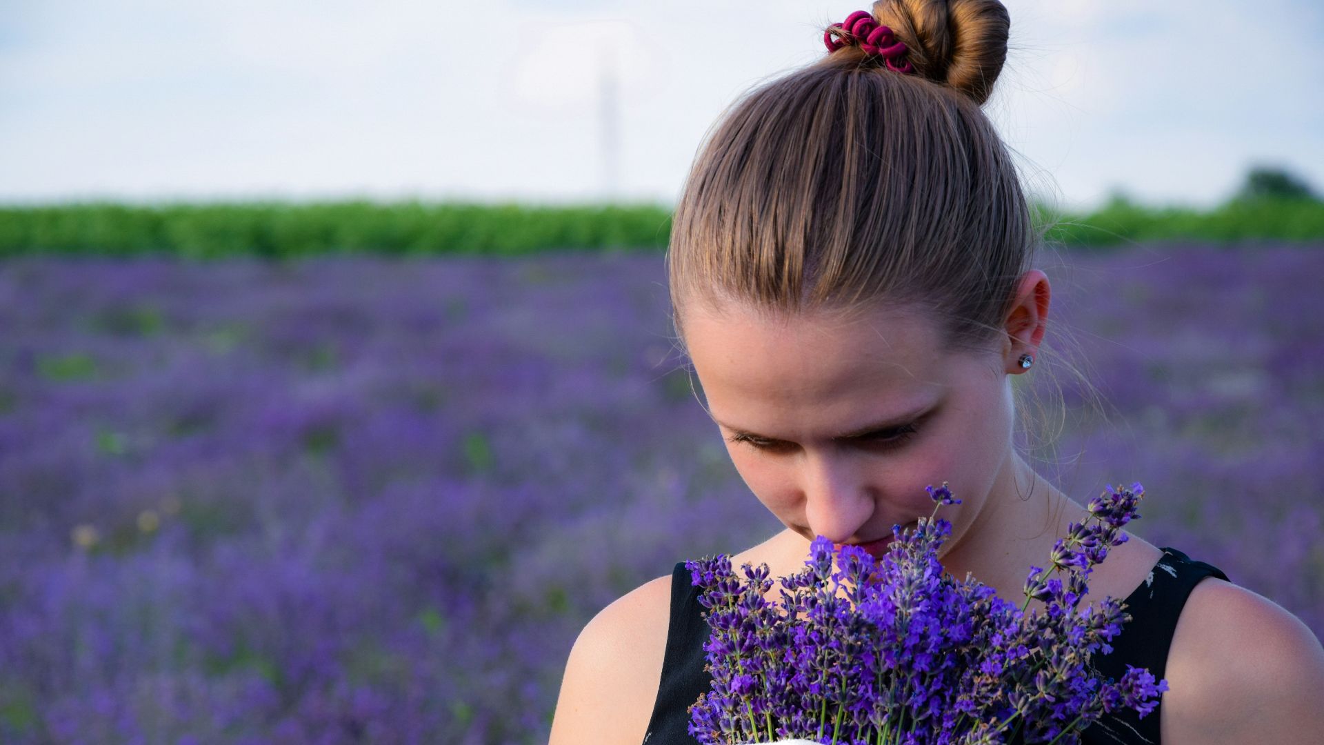 woman smelling bouquet of purple lavender