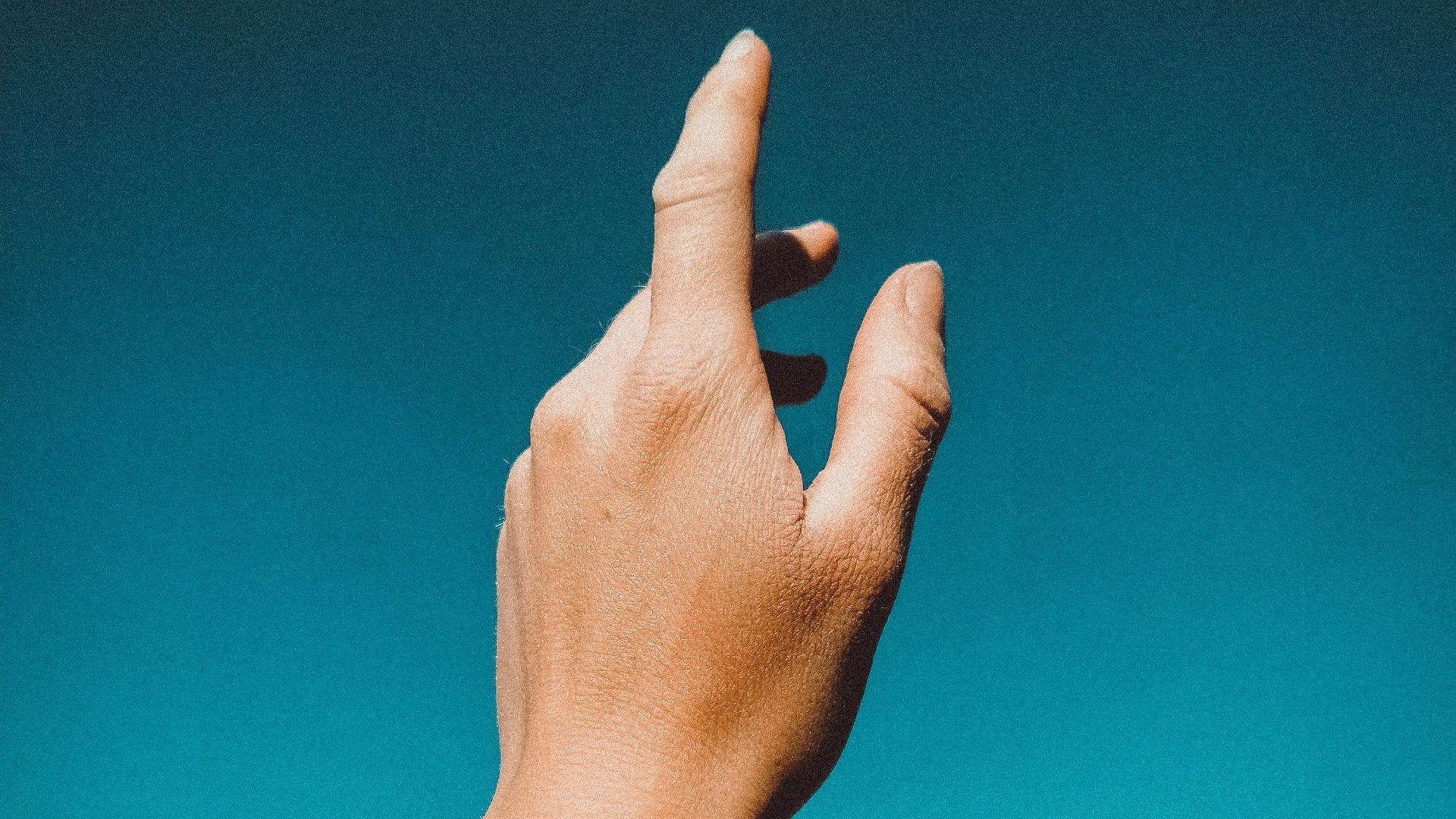 persons left hand doing thumbs up sign