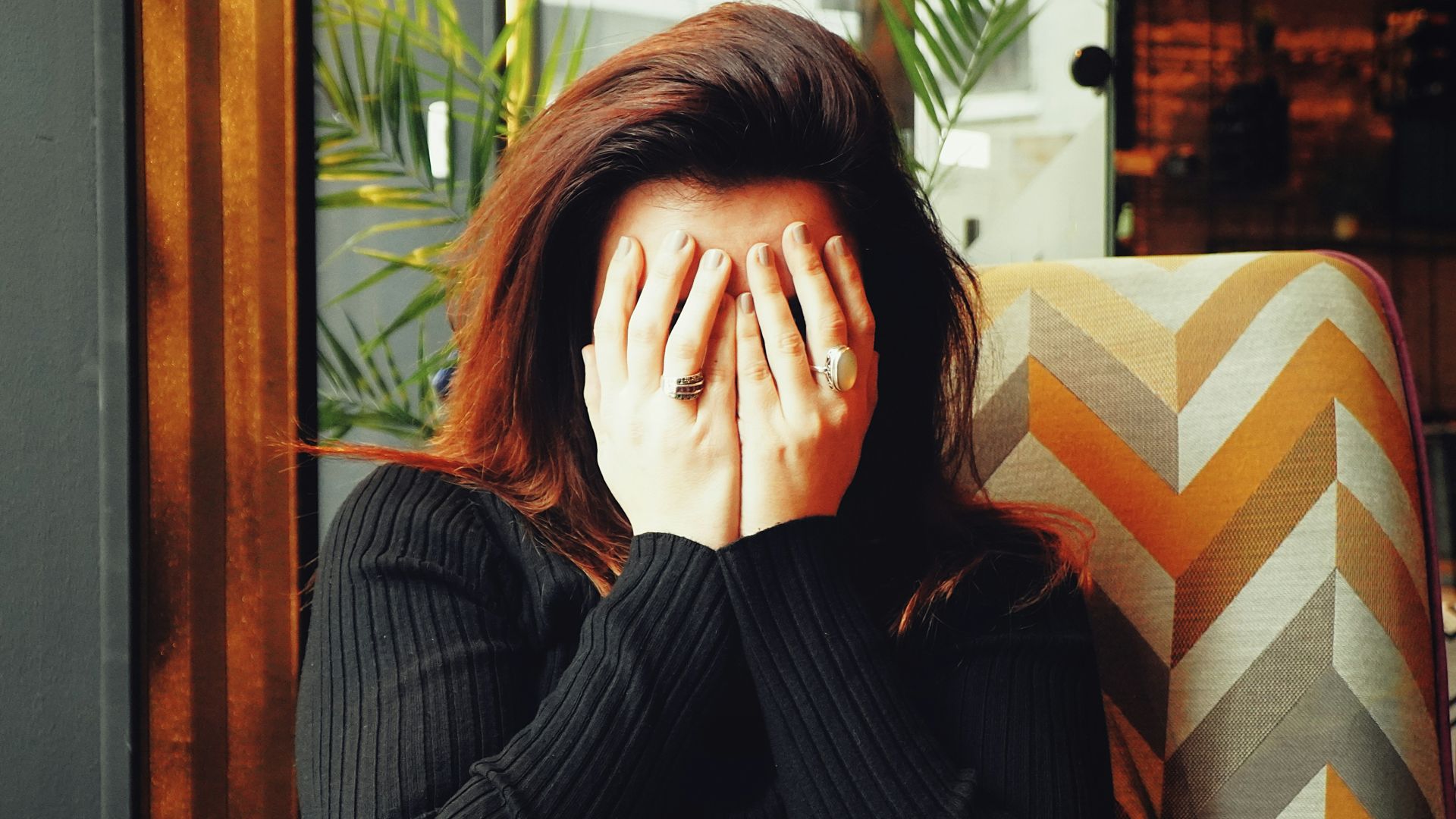 woman in black long sleeve shirt covering her face