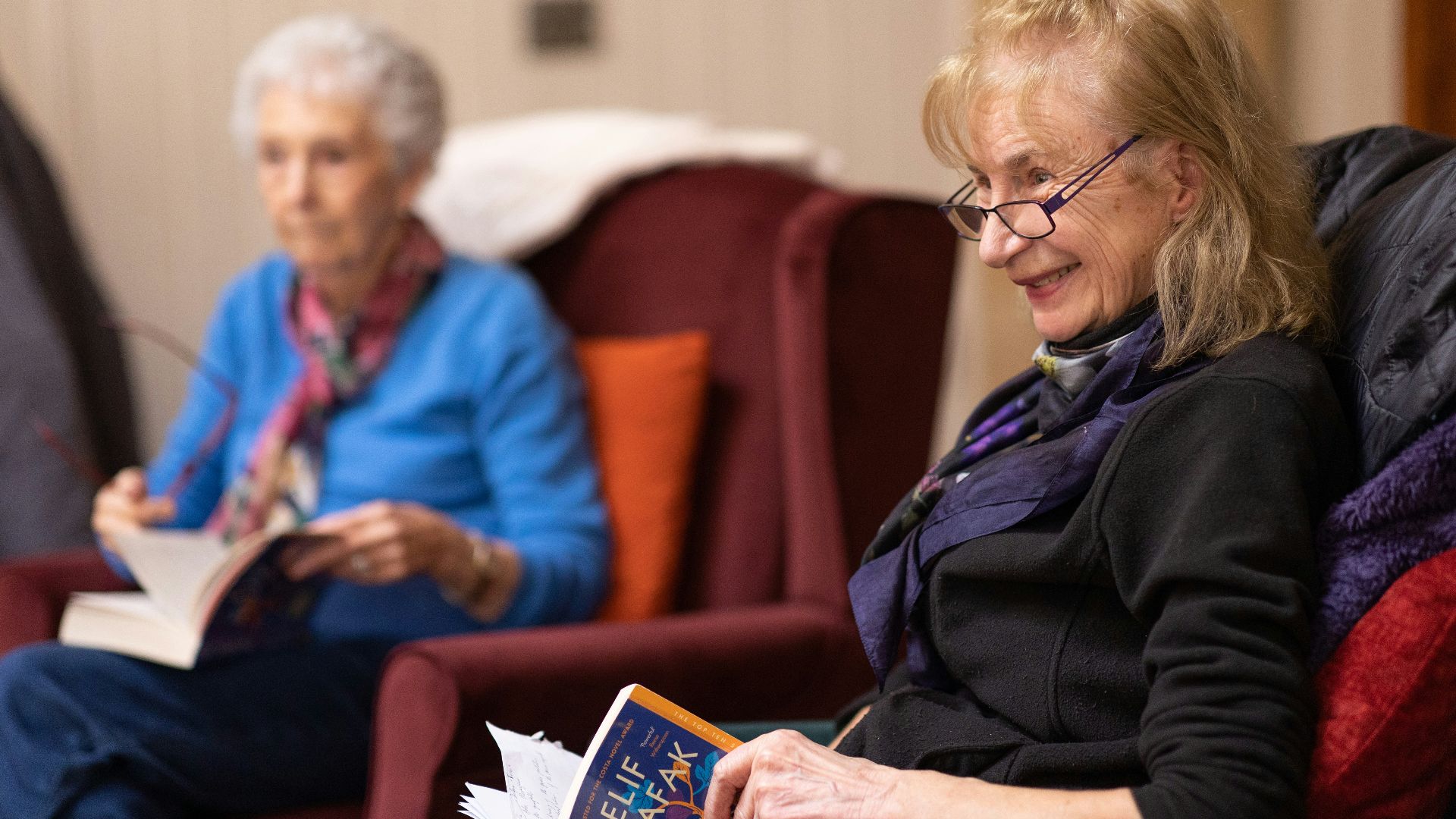 a woman sitting in a chair reading a book