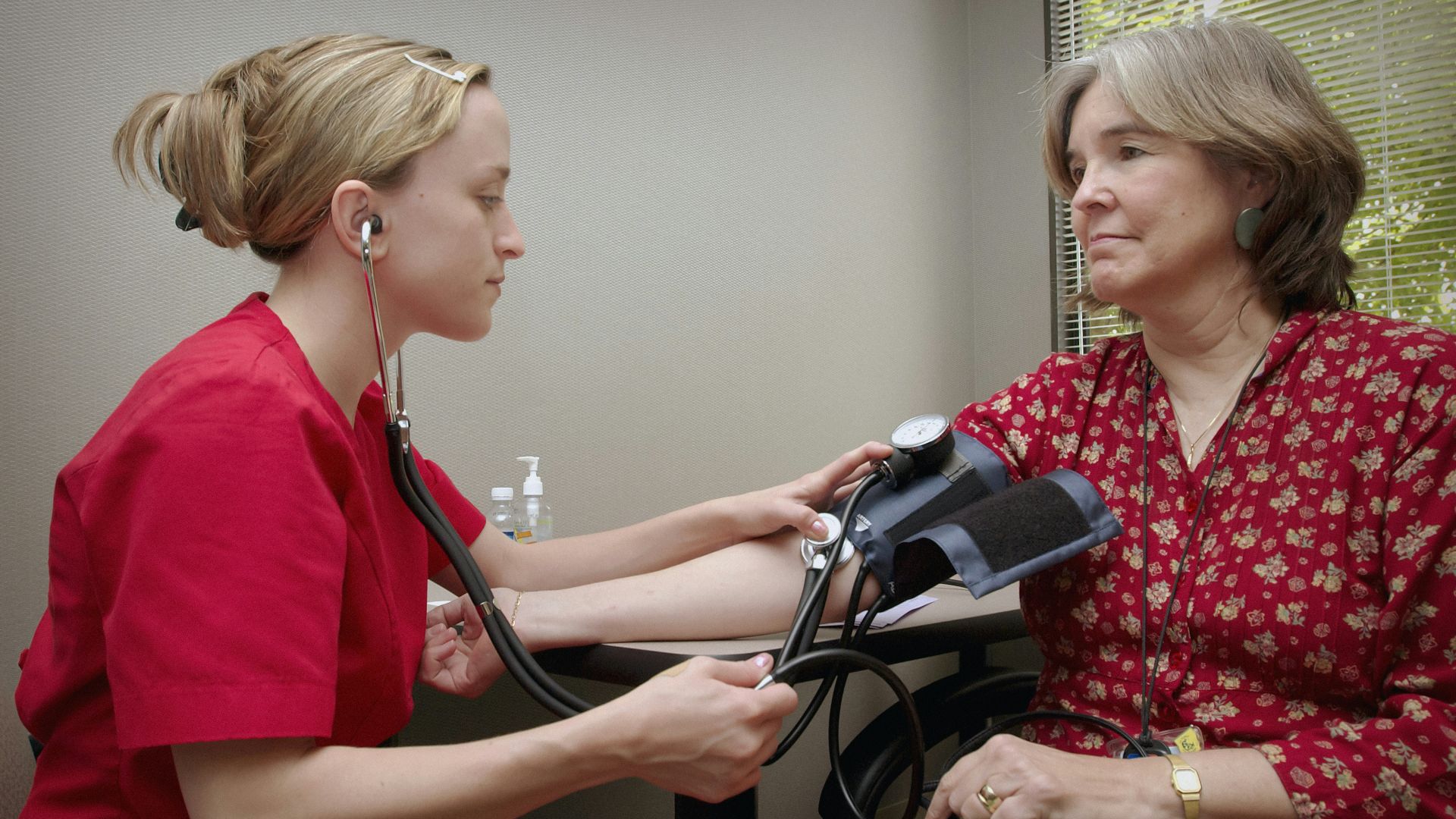 a woman with a stethoscope listening to a patient