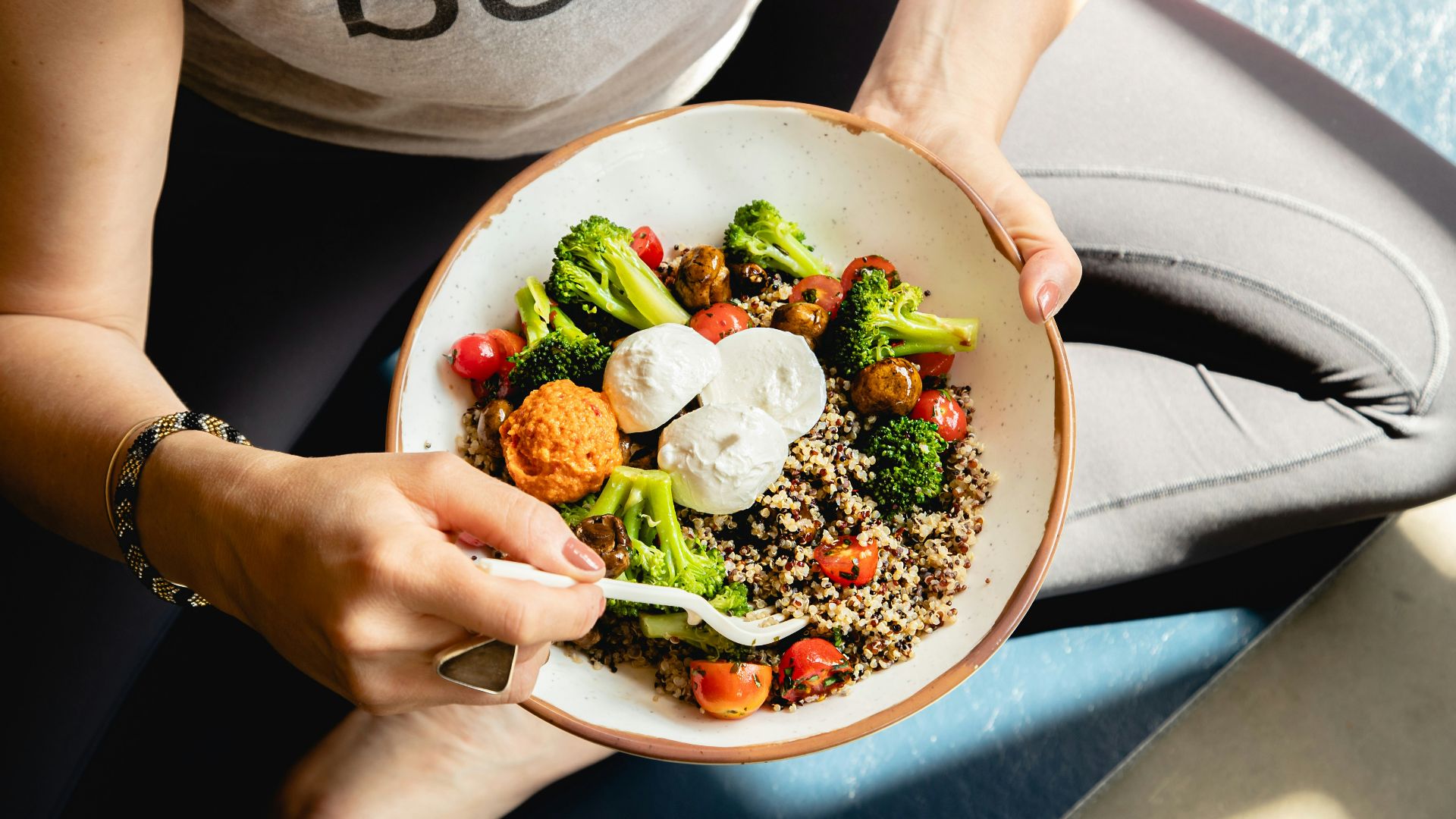 a woman is holding a bowl of food