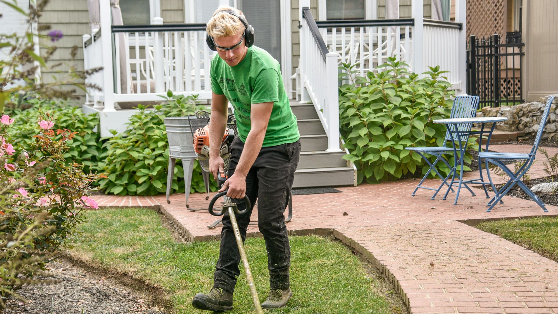 man in green t-shirt and black pants holding black and brown shovel