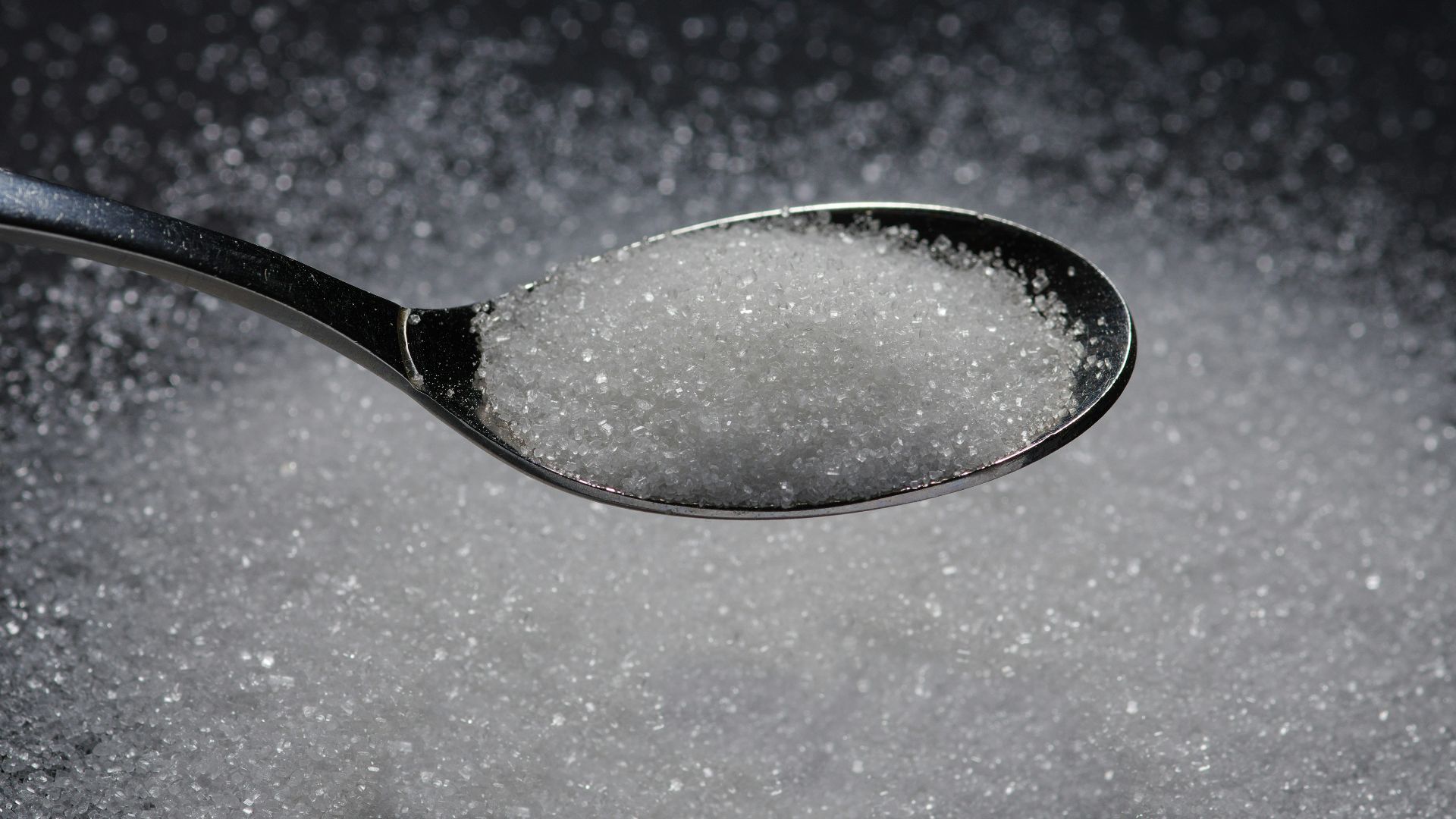a spoon filled with sugar on top of a table