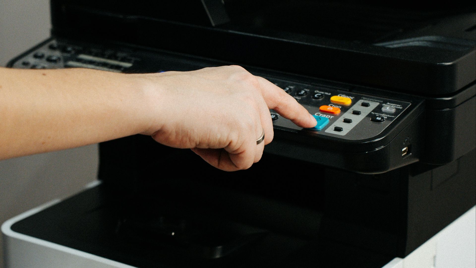 A person is pressing a button on a printer