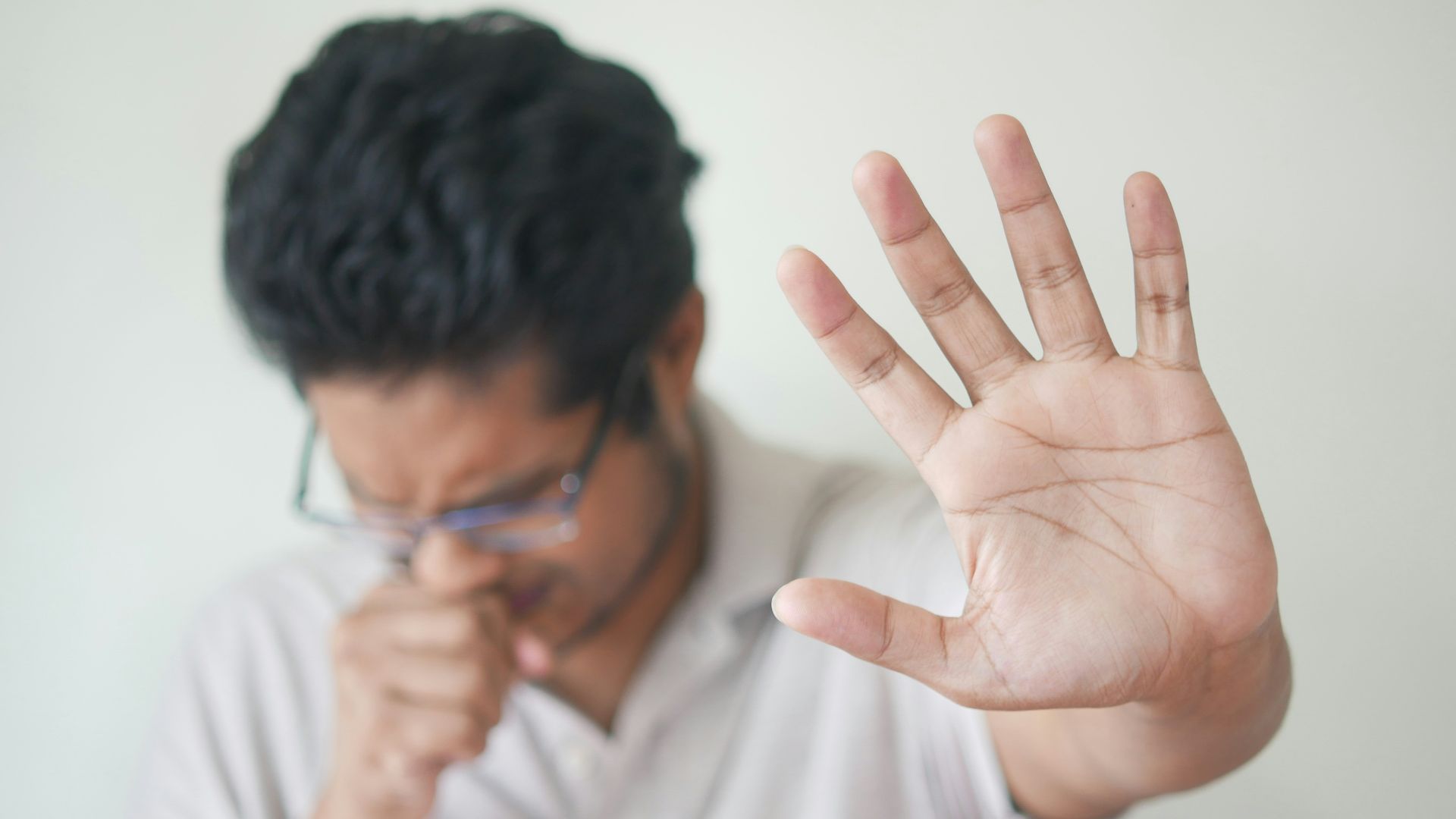 a man holding his hand up in front of his face