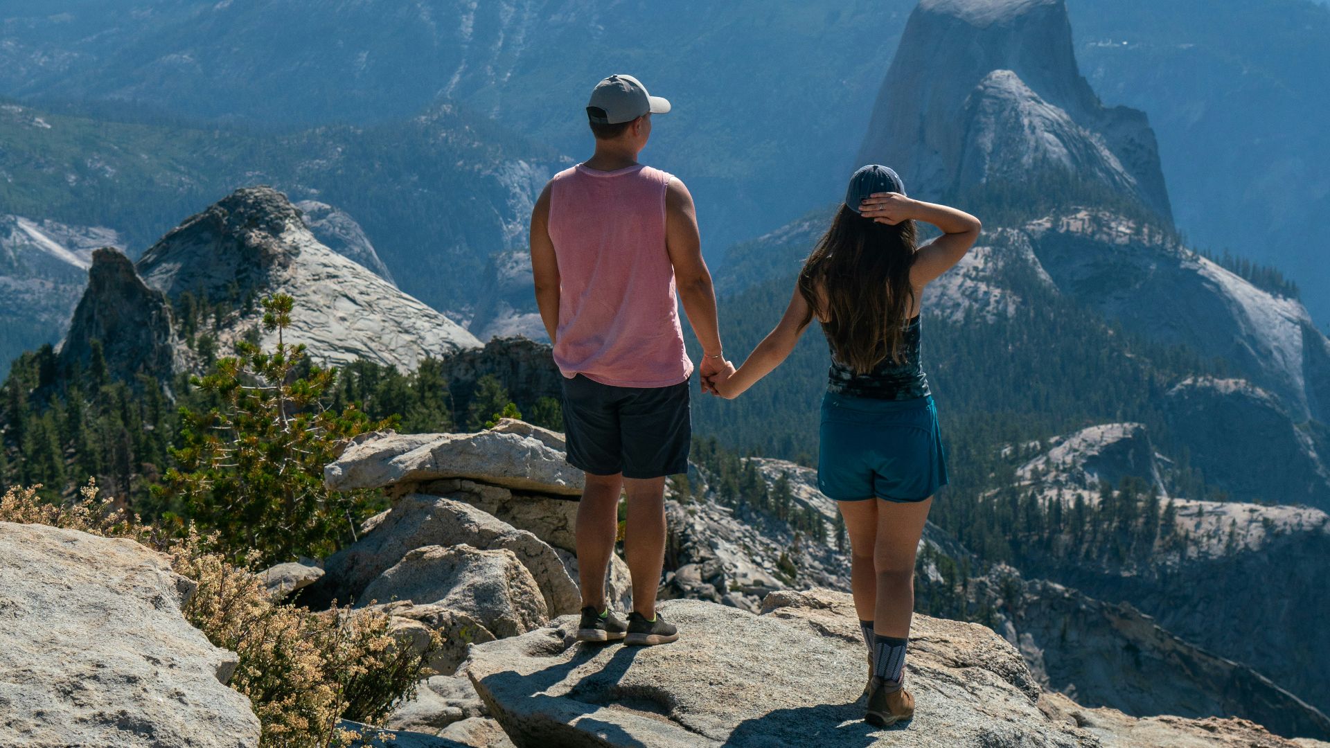 a man and a woman standing on top of a mountain