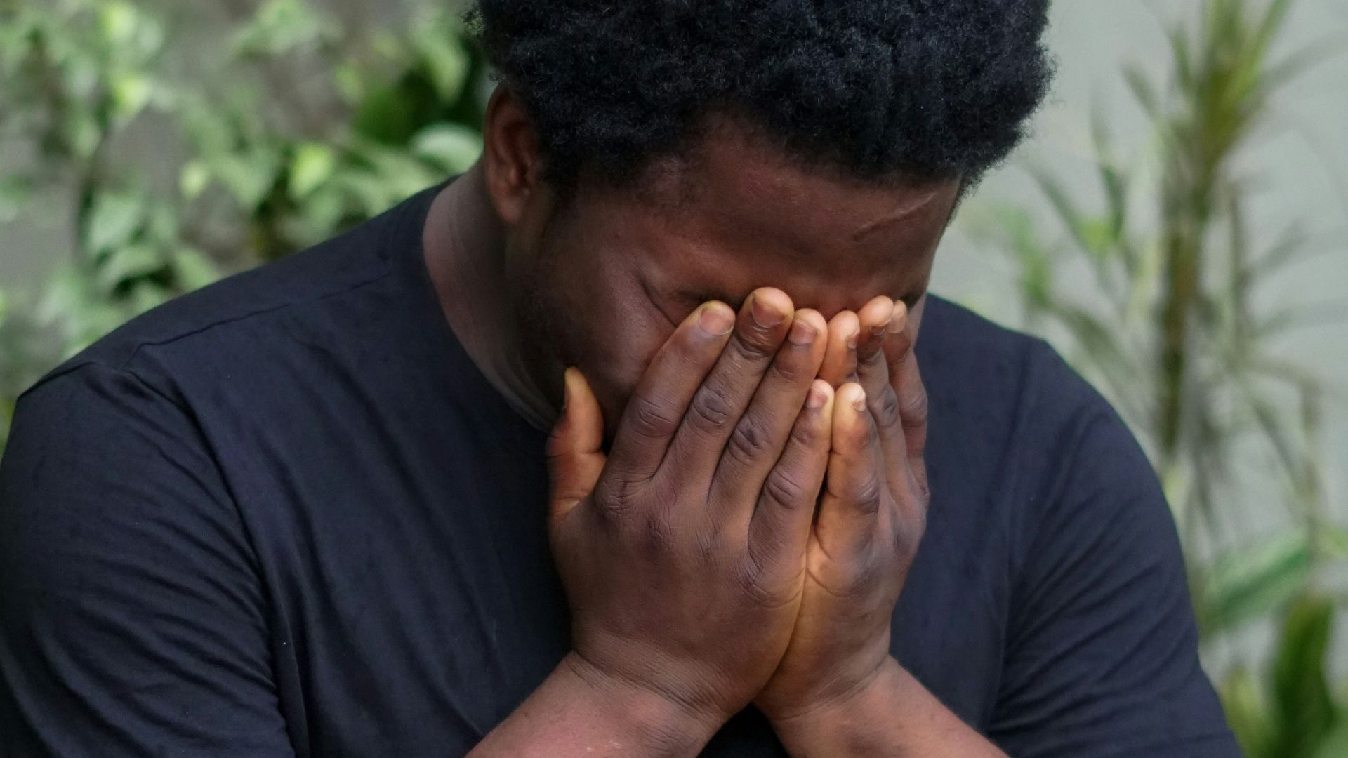 a man covers his face with his hands