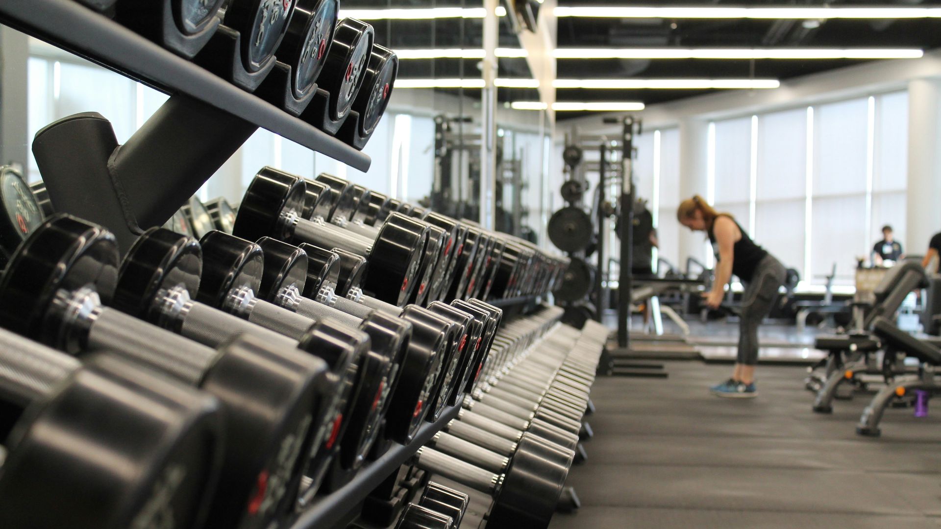 woman standing surrounded by exercise equipment
