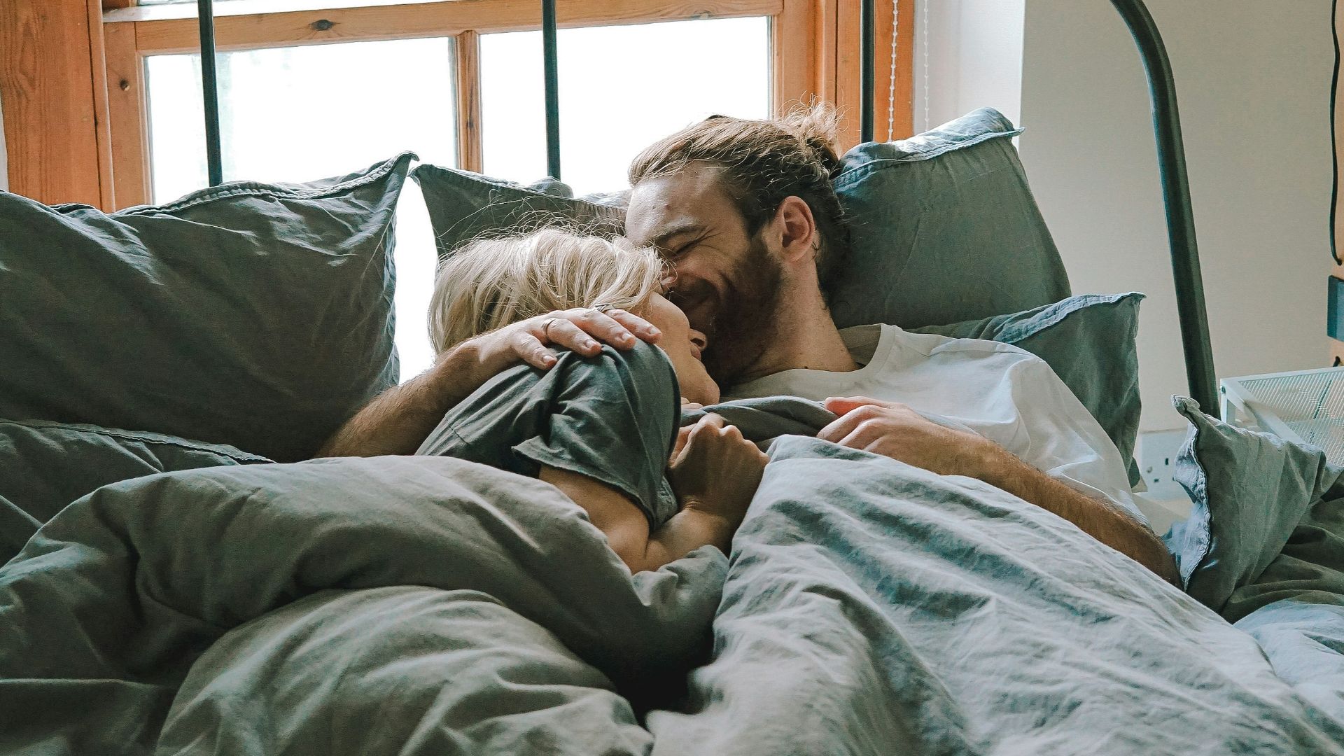 man kissing woman on her forehead
