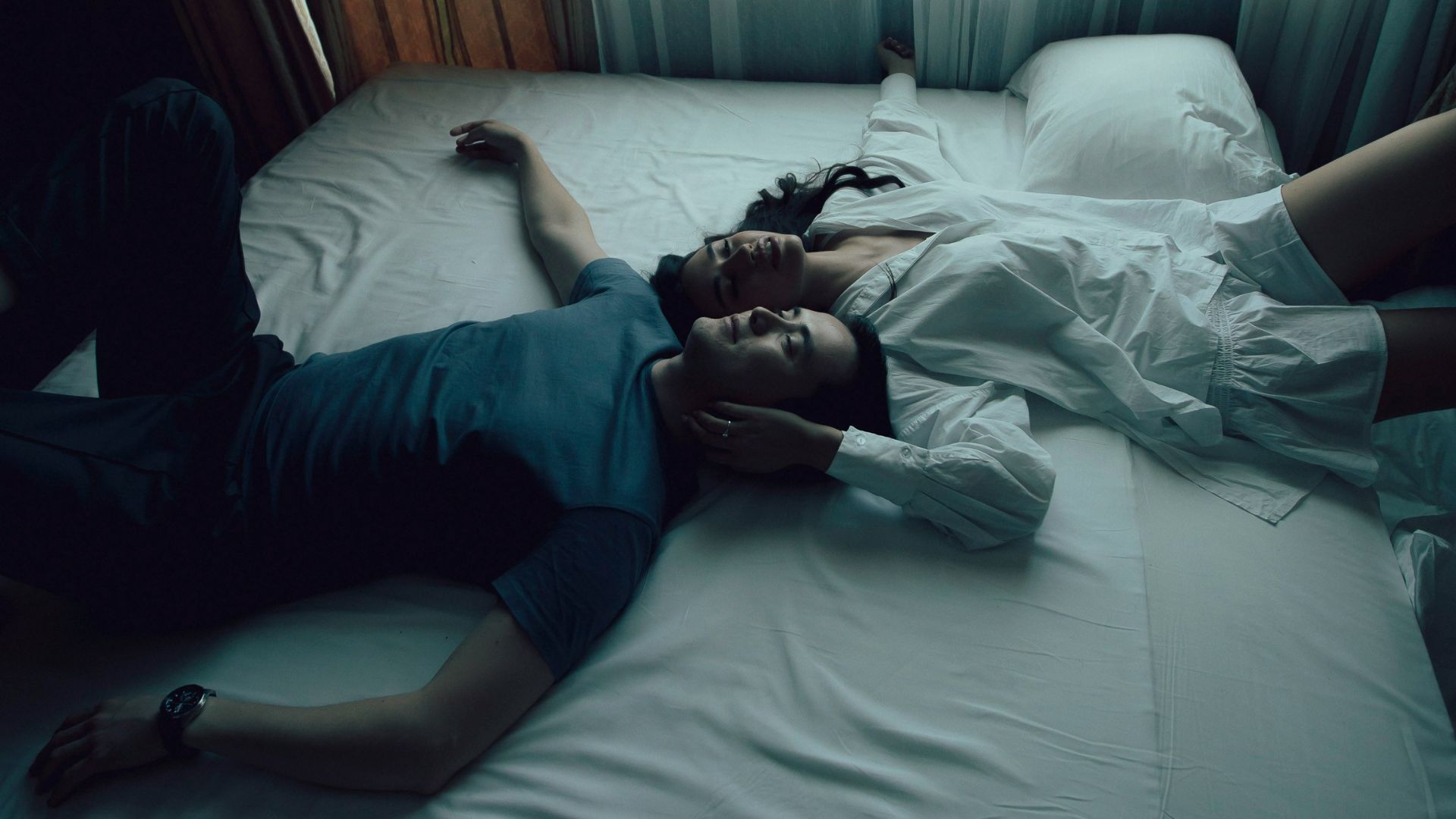 man in blue shirt lying on bed