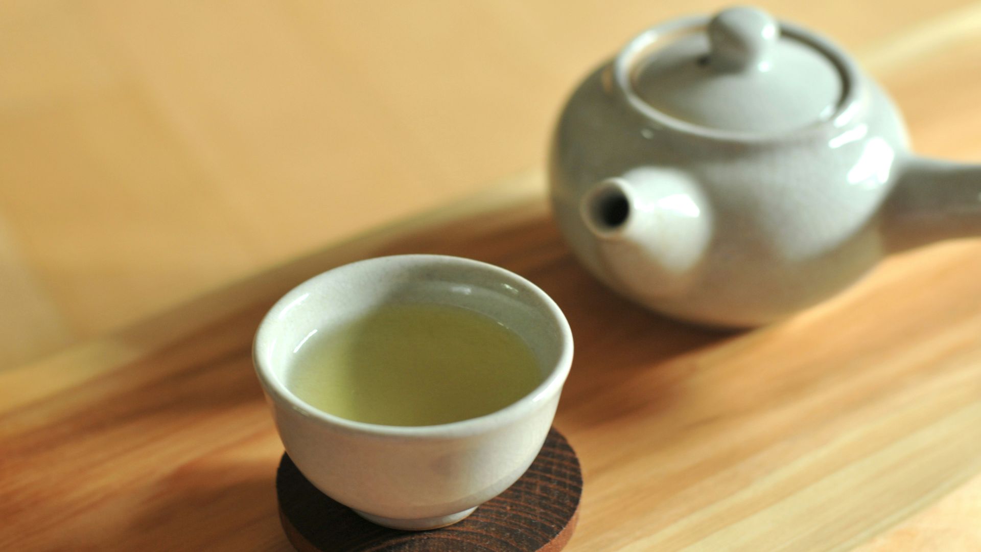 white ceramic teacup on brown wooden table