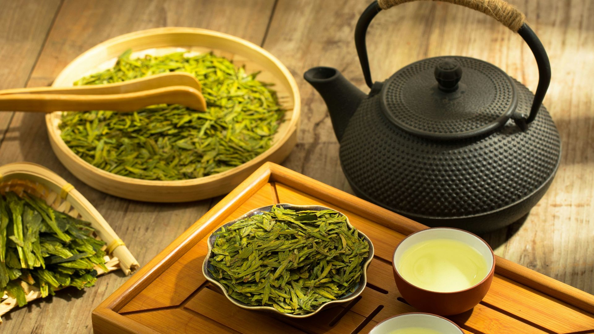 a tea set with a teapot and two cups of green tea