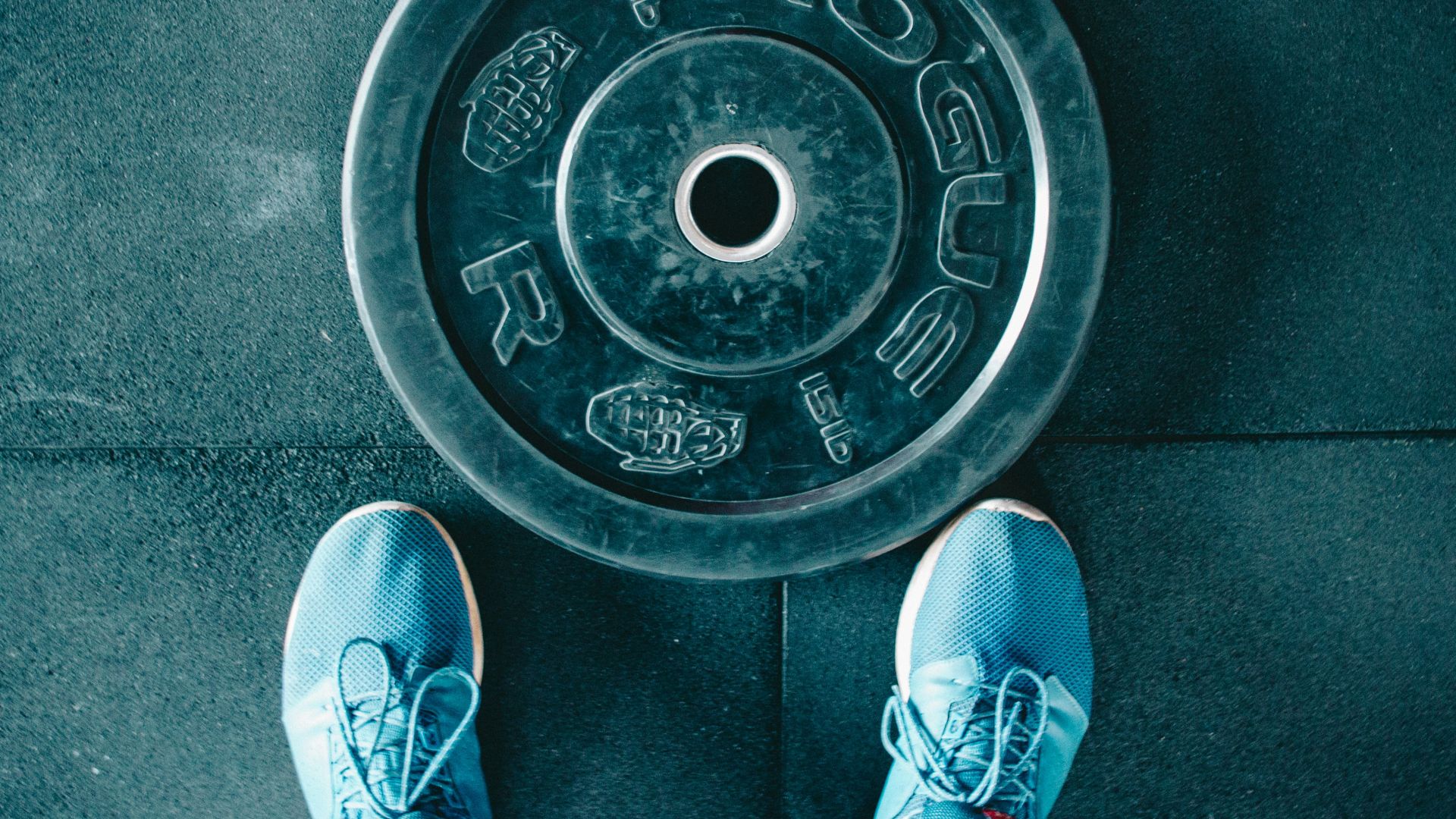 person standing beside black weights
