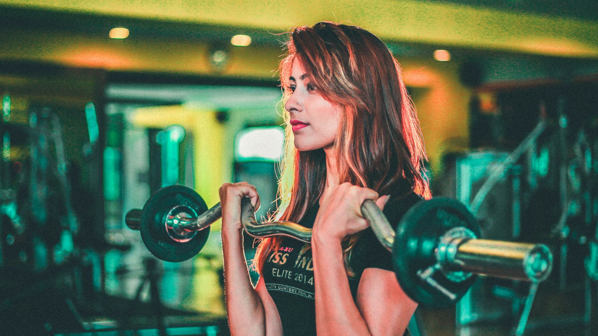 woman lifting black and gray barbell
