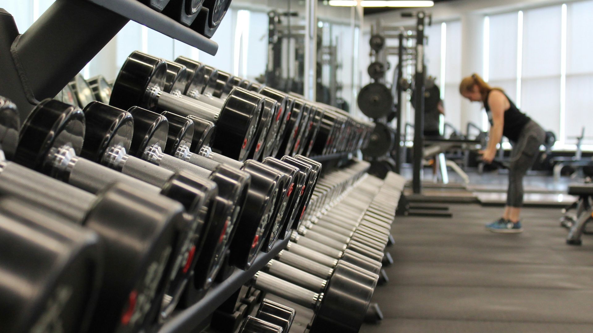 woman standing surrounded by exercise equipment