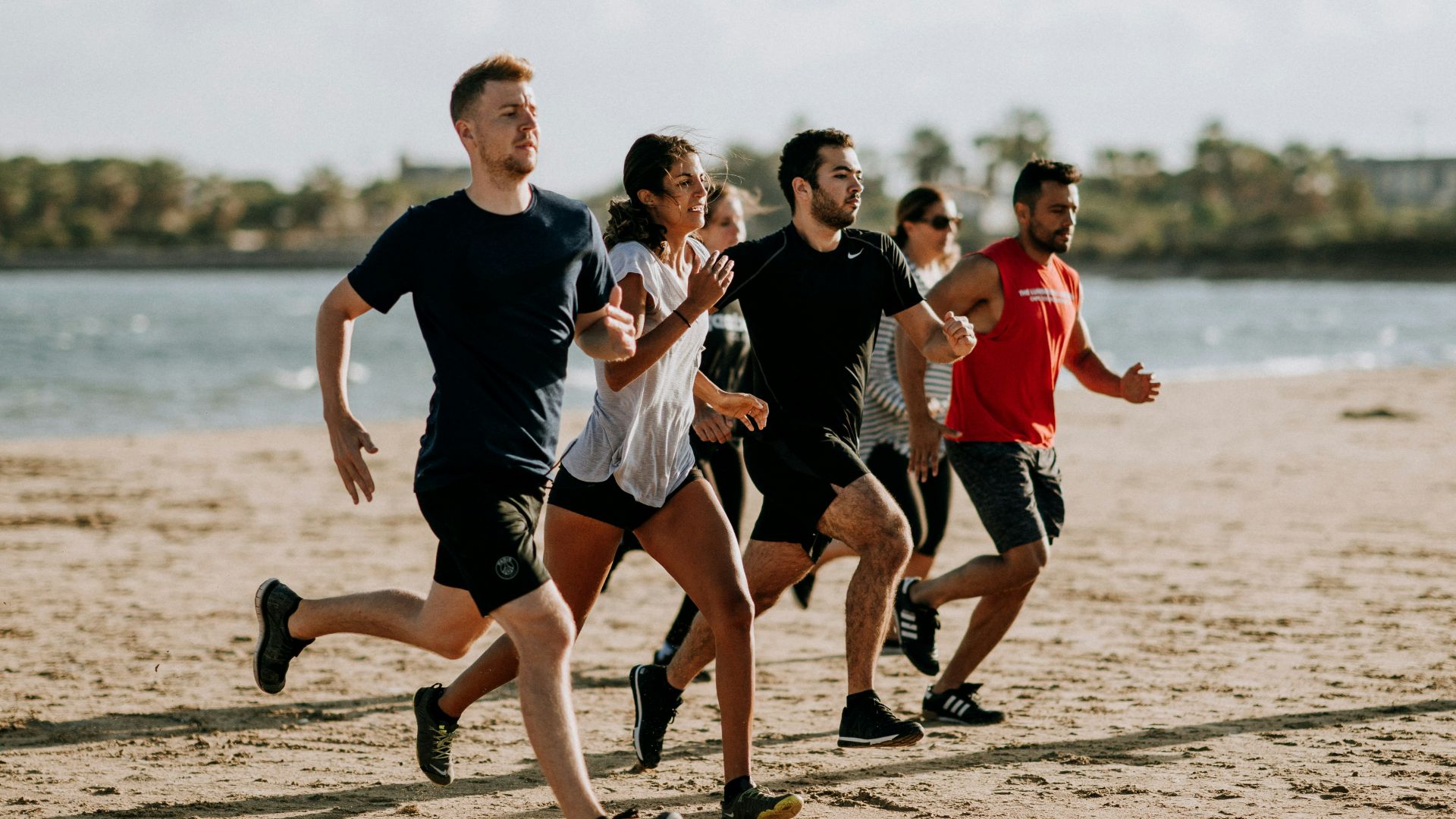men and women running on sea shore