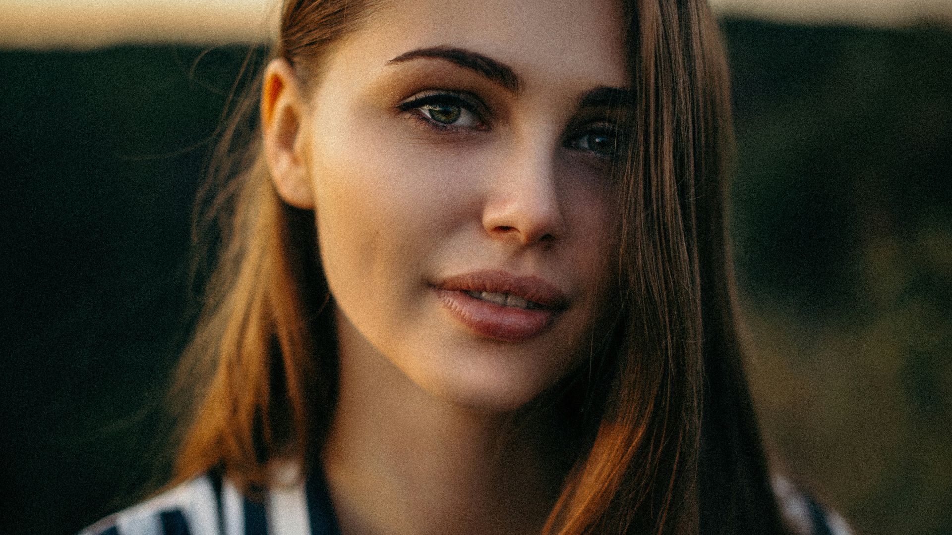 smiling woman wearing white and black pinstriped collared top