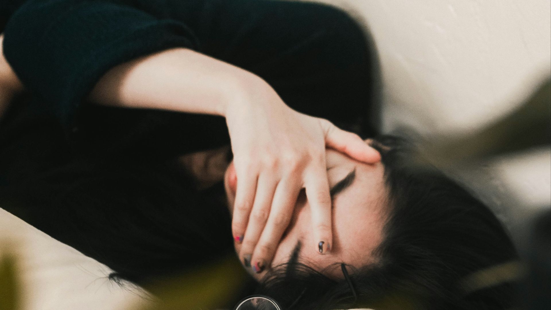 woman in black long sleeve shirt covering her face