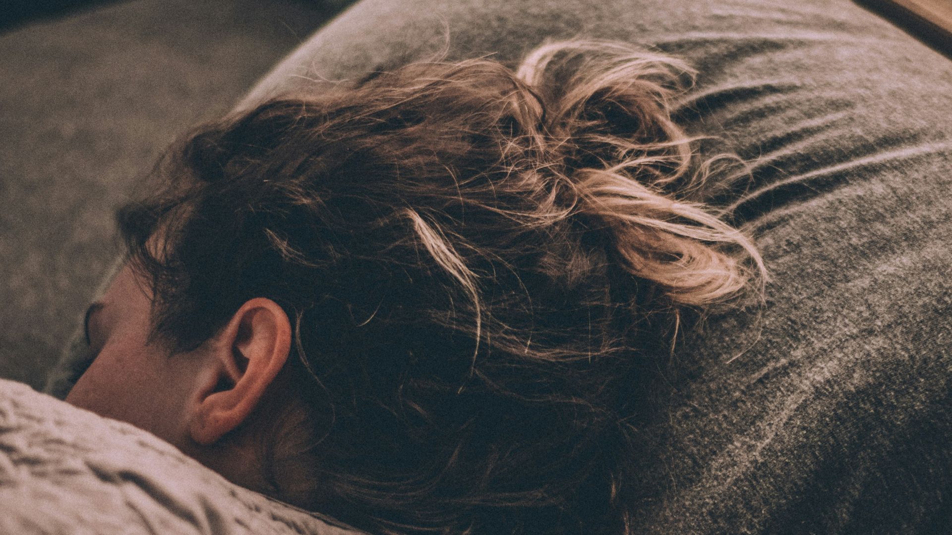 woman sleeping on bed under blankets