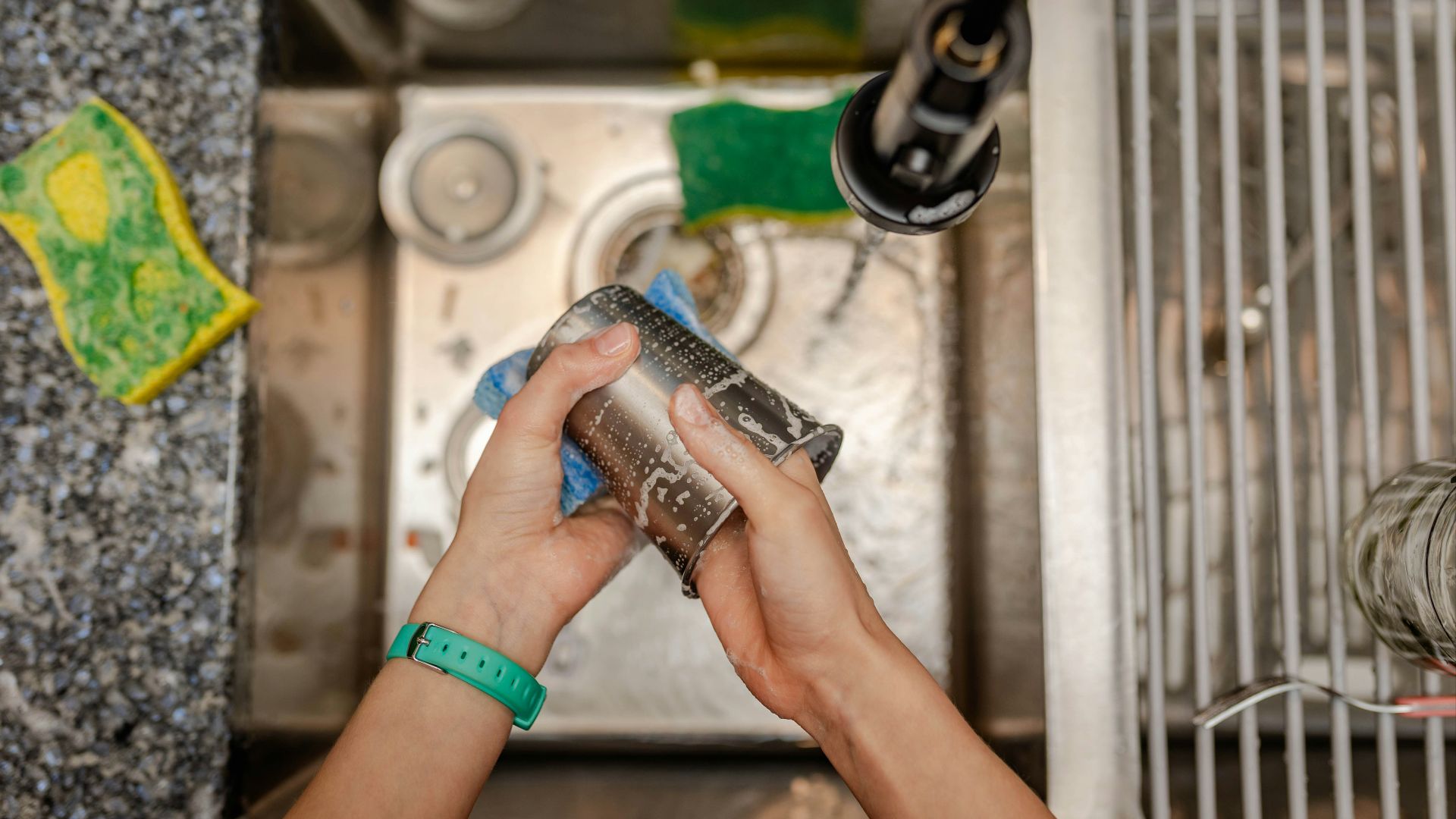 A person is cleaning a sink with a rag