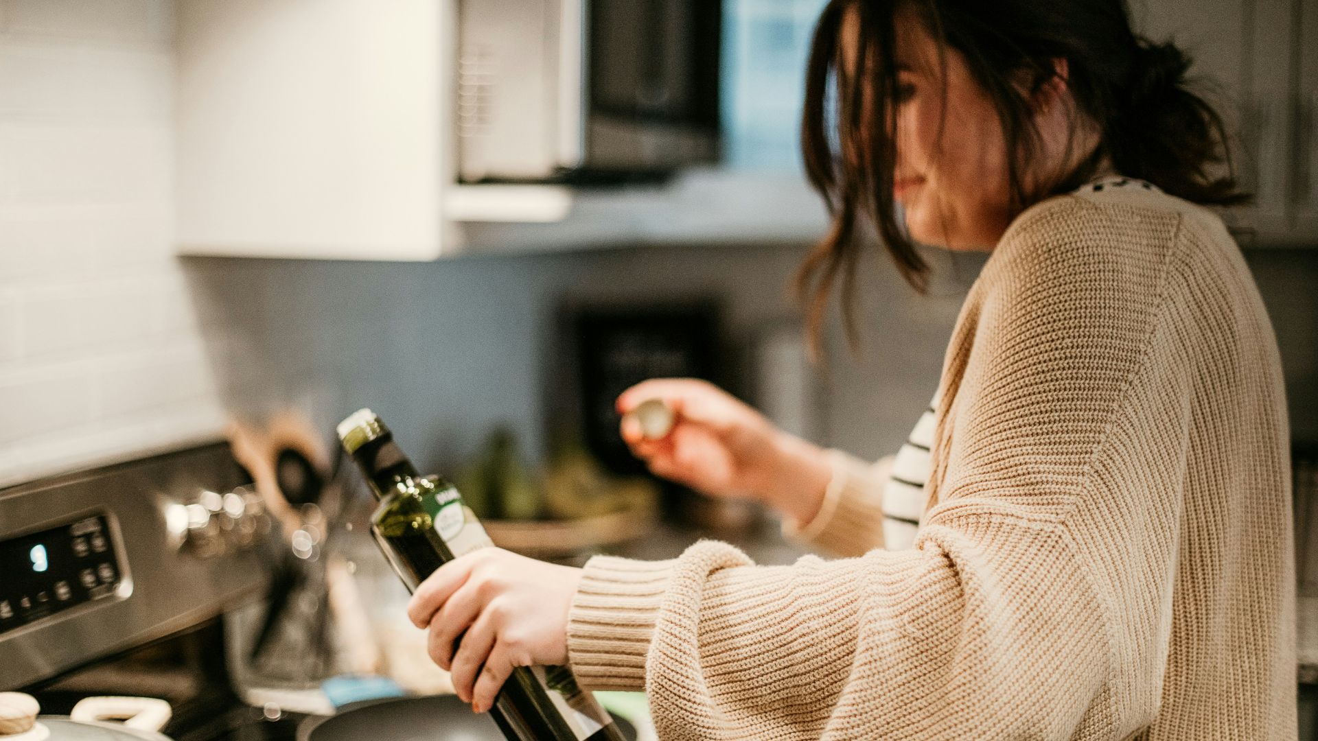 woman in white long sleeve shirt holding bottle