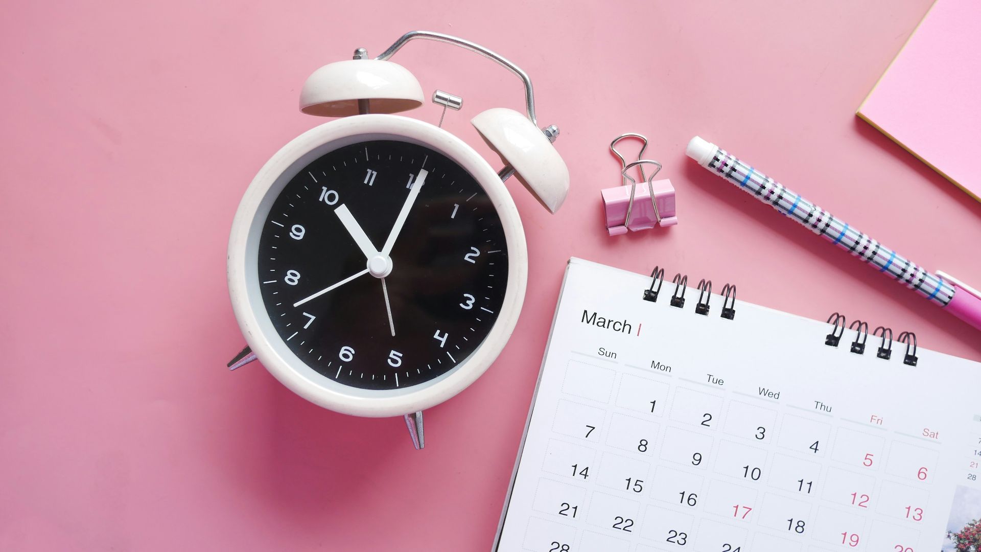 white and pink analog alarm clock