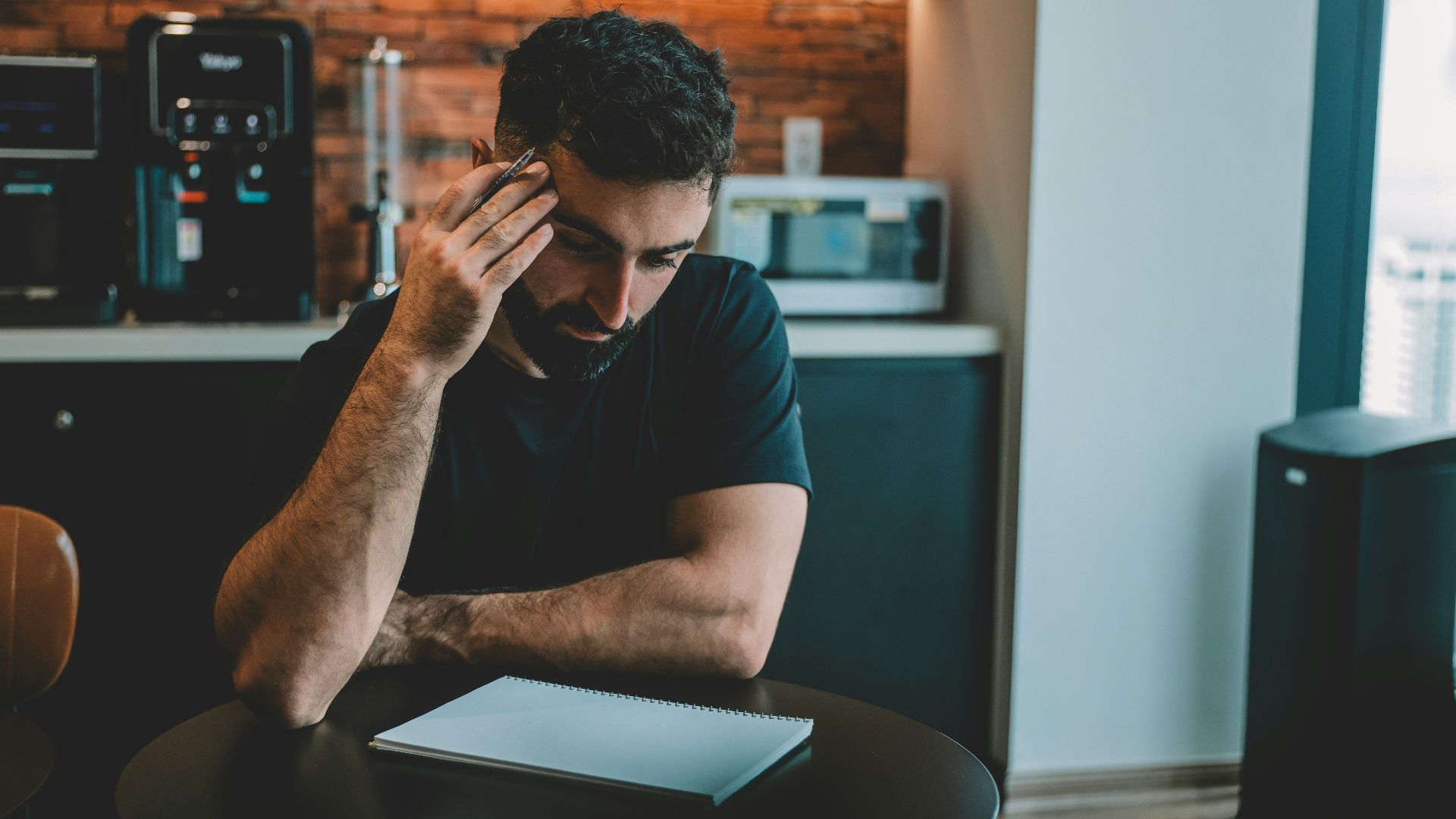 Man holding head while looking at document