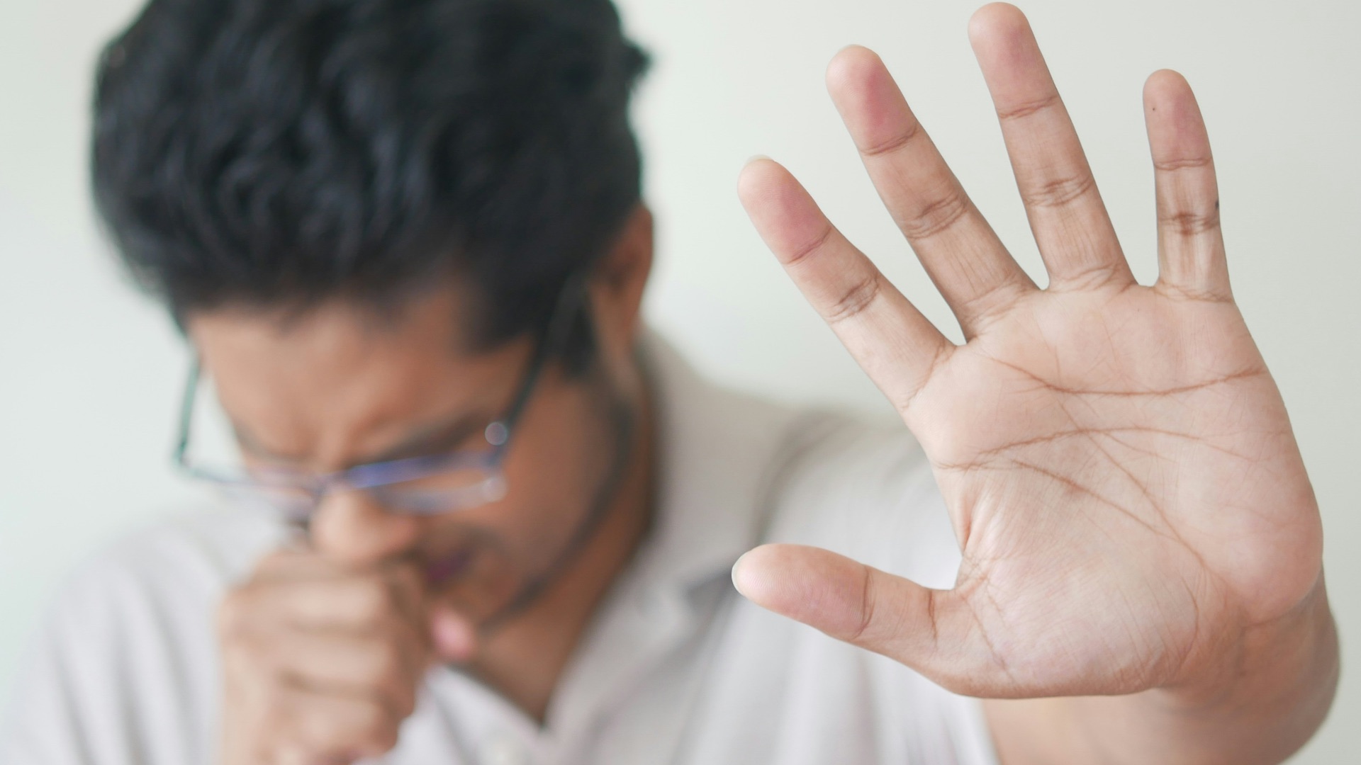 a man holding his hand up in front of his face