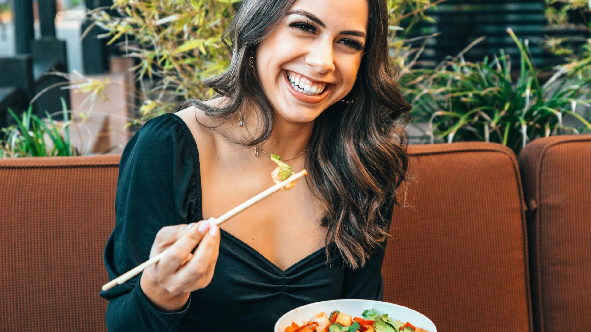 woman in blue long sleeve shirt holding chopsticks