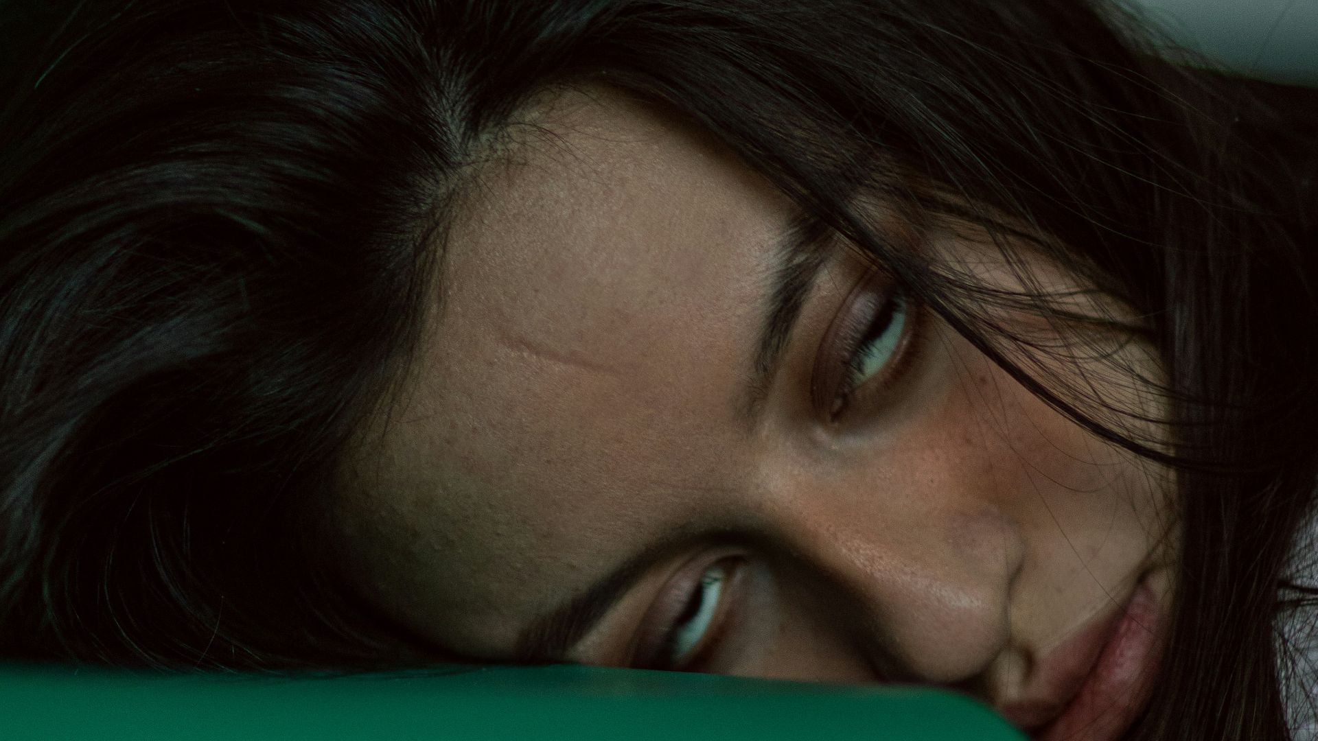 woman lying on green textile