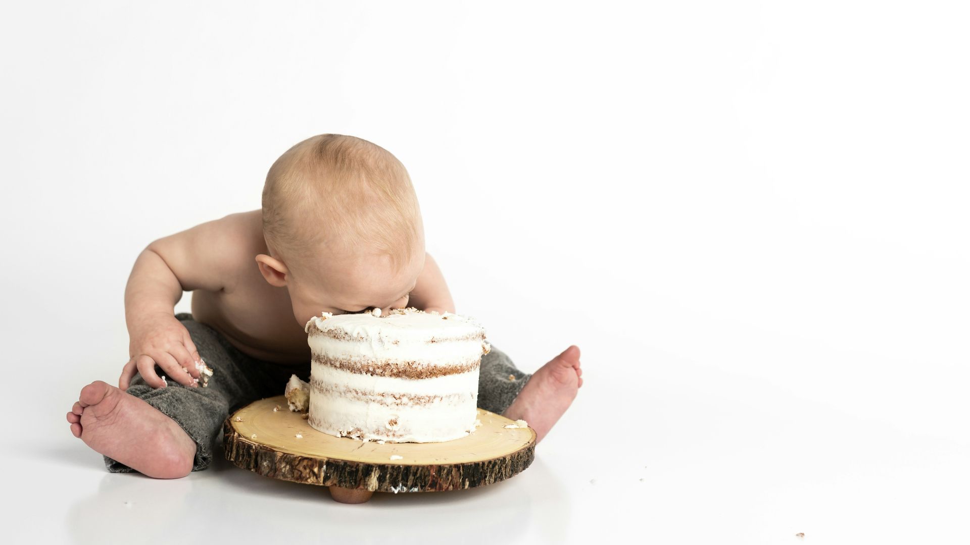 kid sitting beside round cake close-up photography