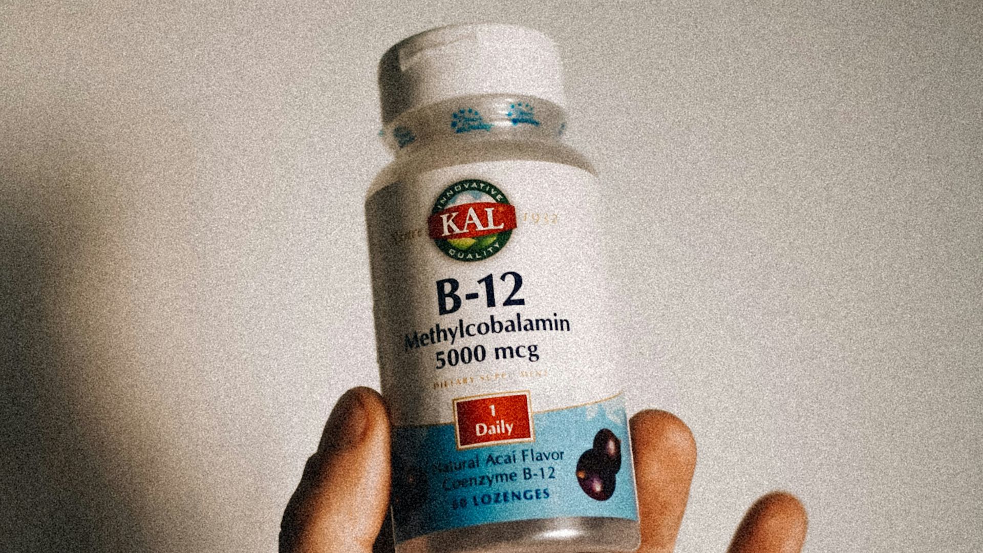 a person holding a bottle of vitamins in their hand