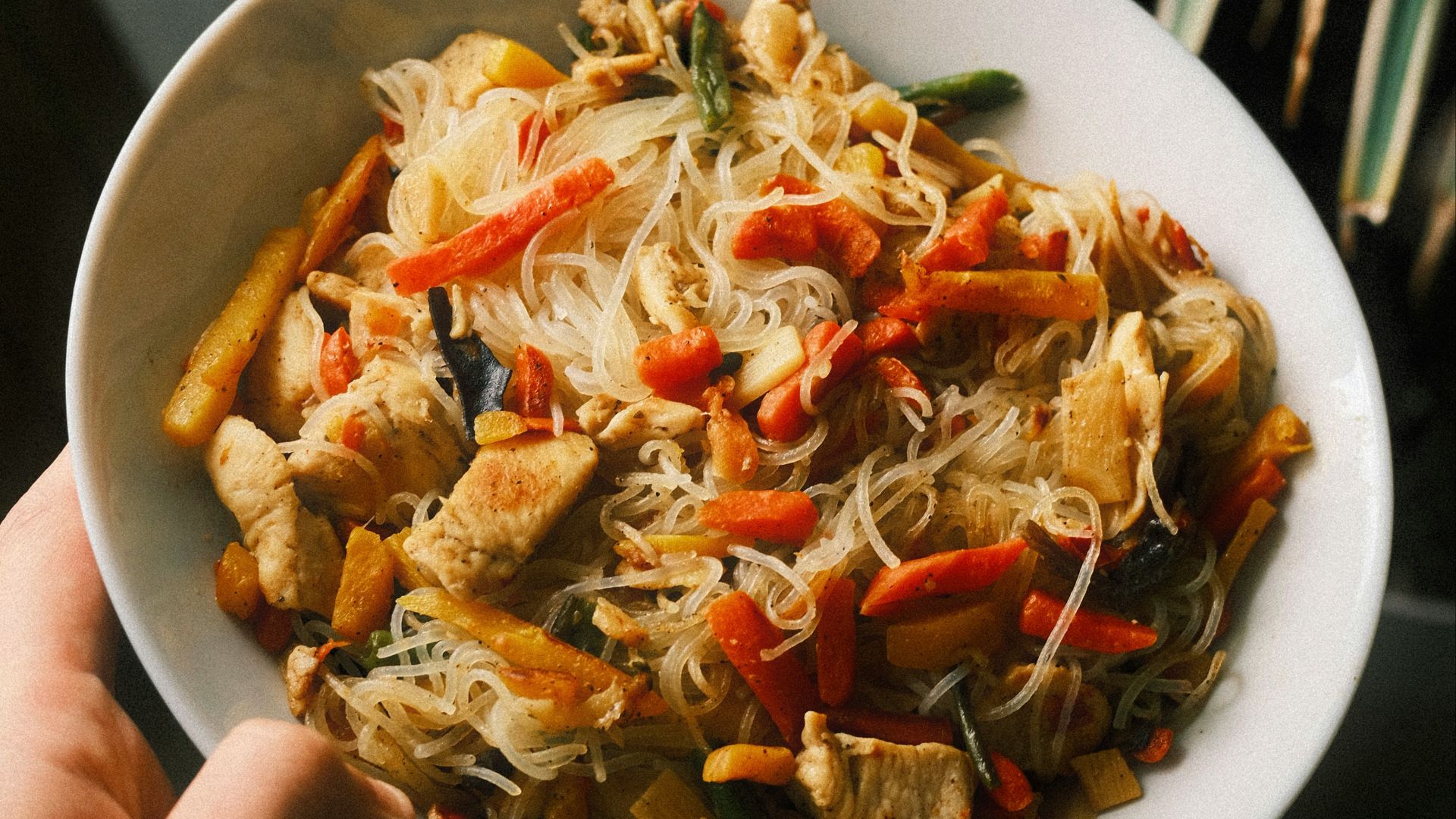 Chicken stir-fry with noodles and vegetables in a bowl