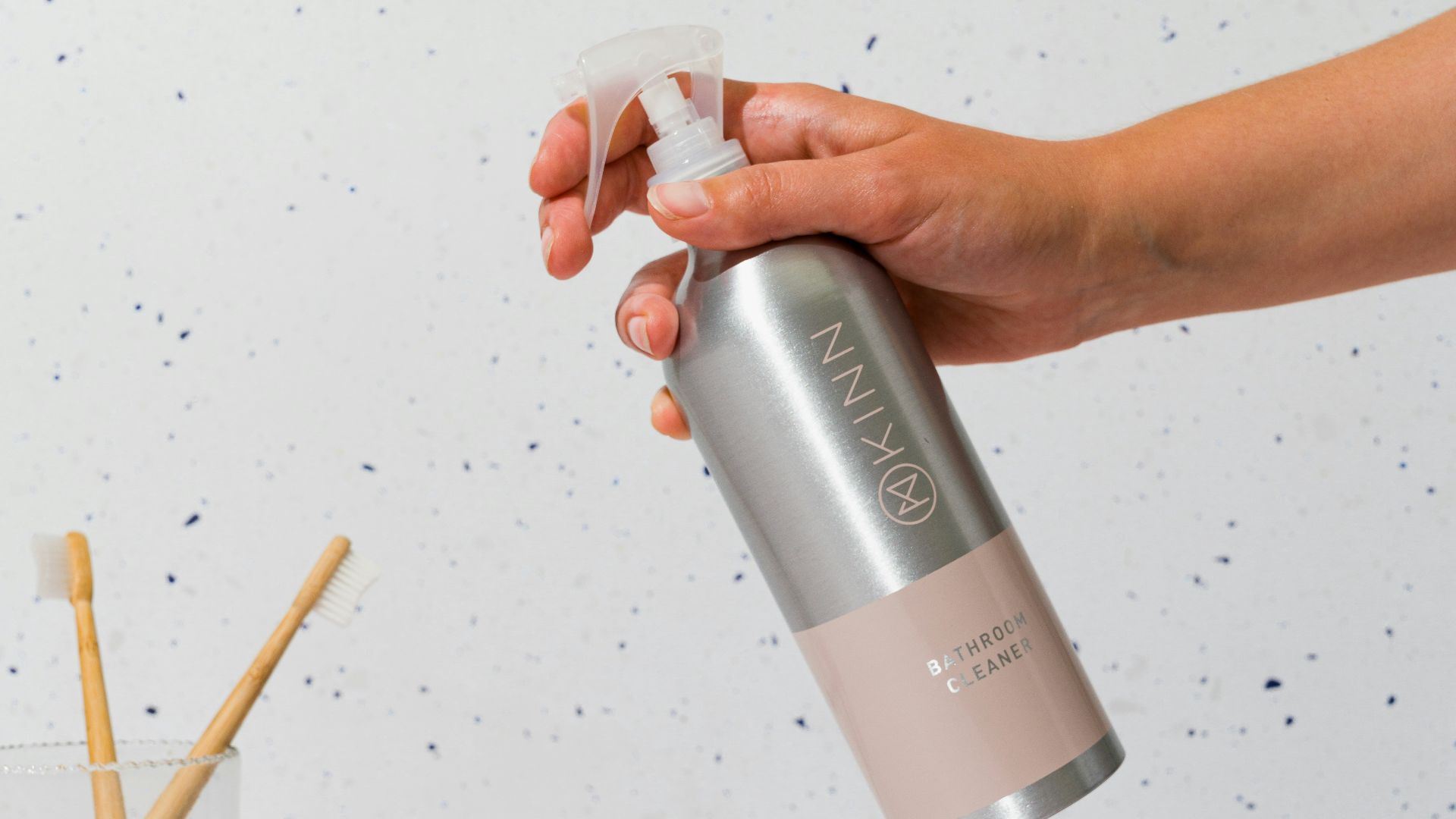 a person is holding a spray bottle over a cup