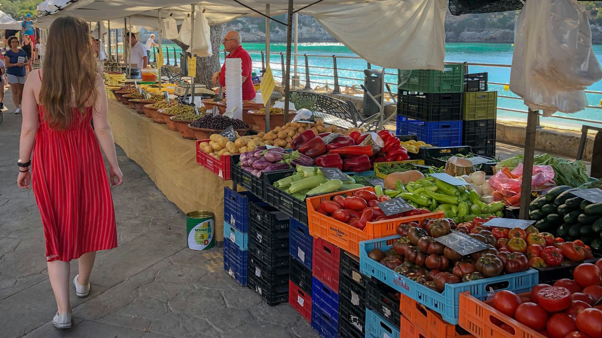 woman walking beside fruit and vegetable vendors