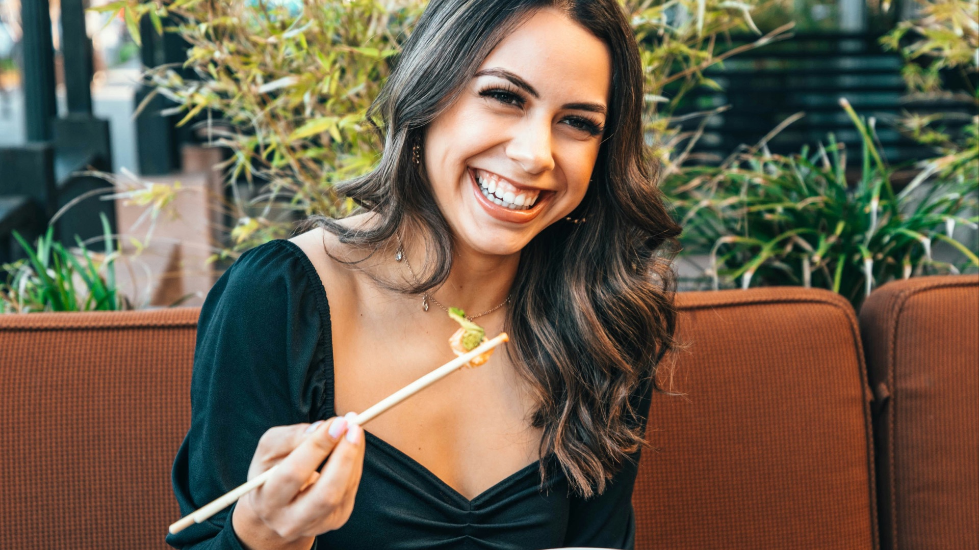 woman in blue long sleeve shirt holding chopsticks