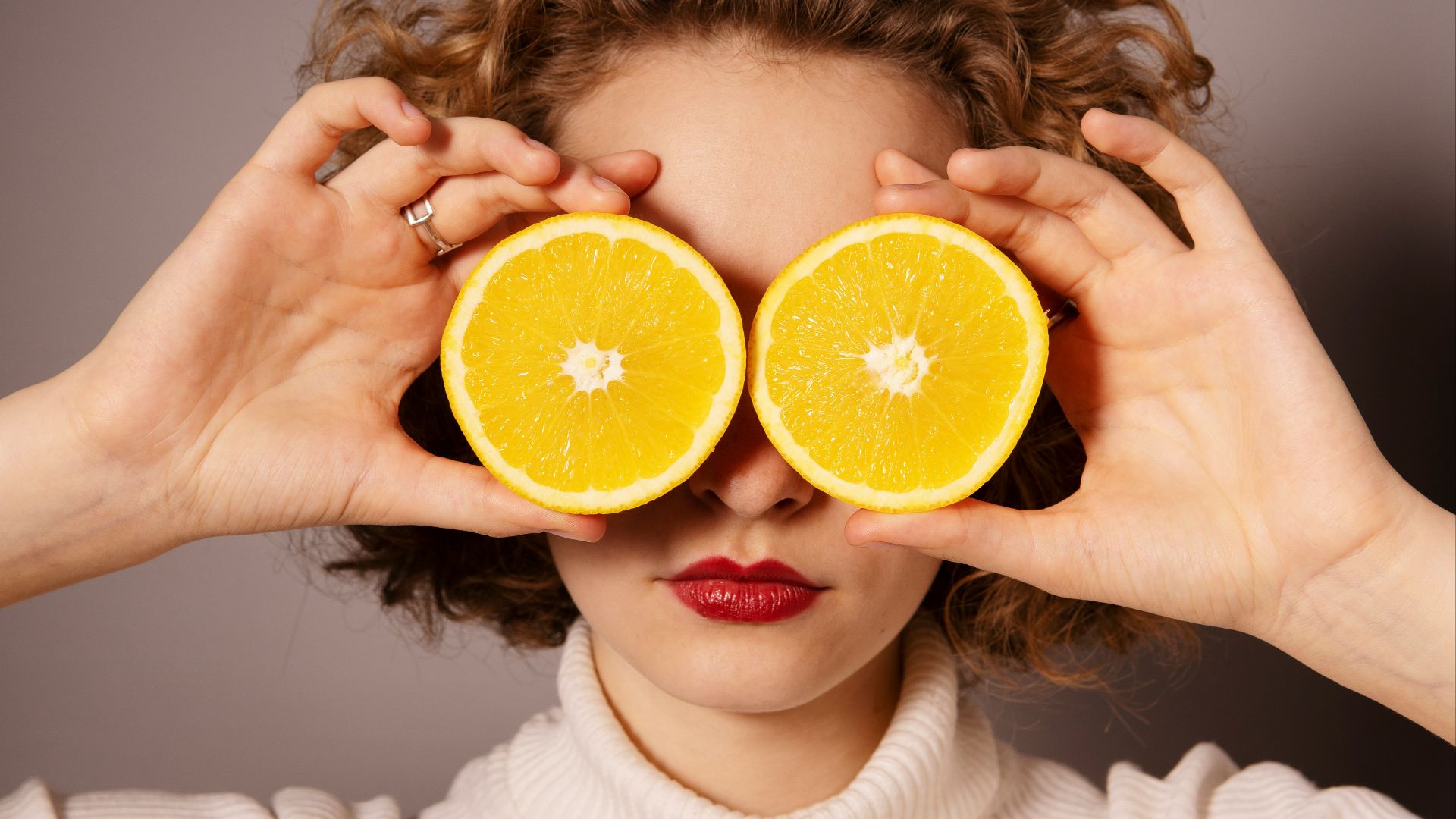 woman holding sliced orange fruit