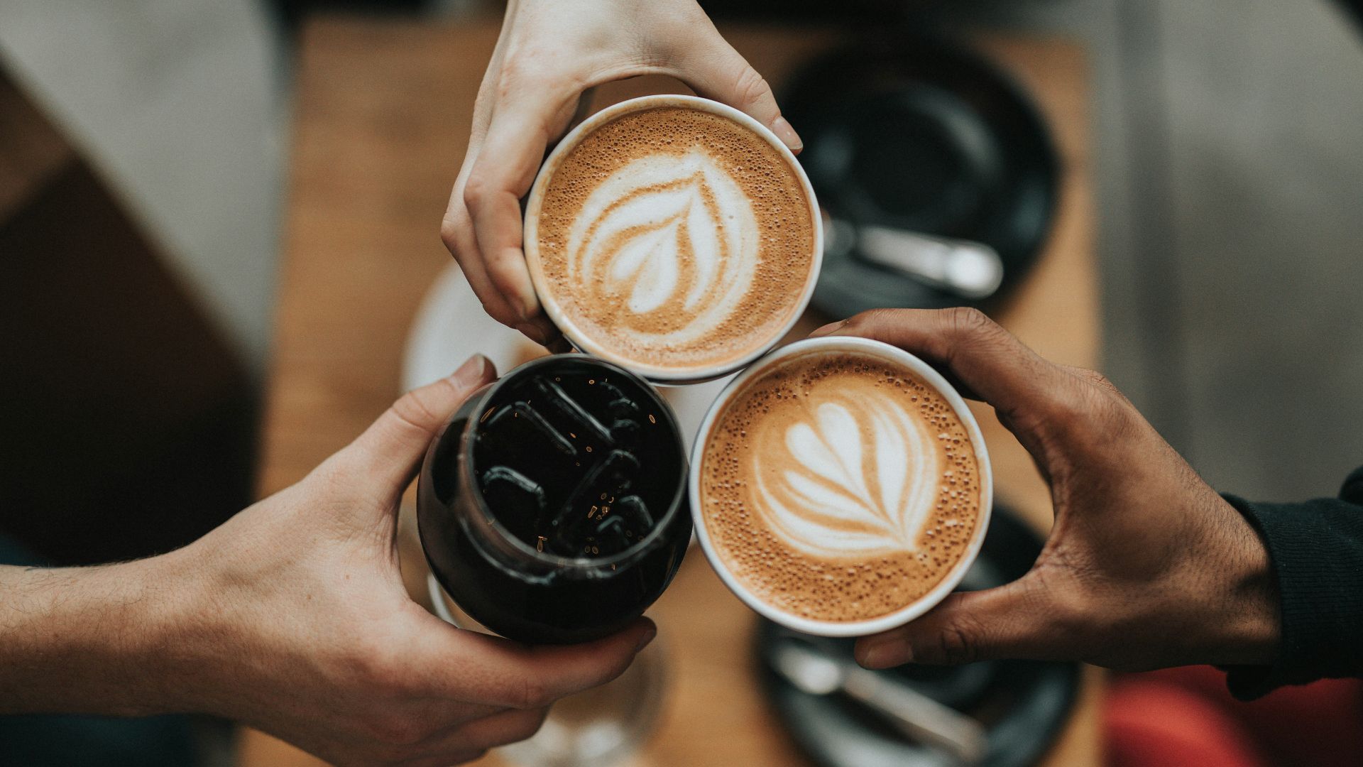 three person holding beverage cups