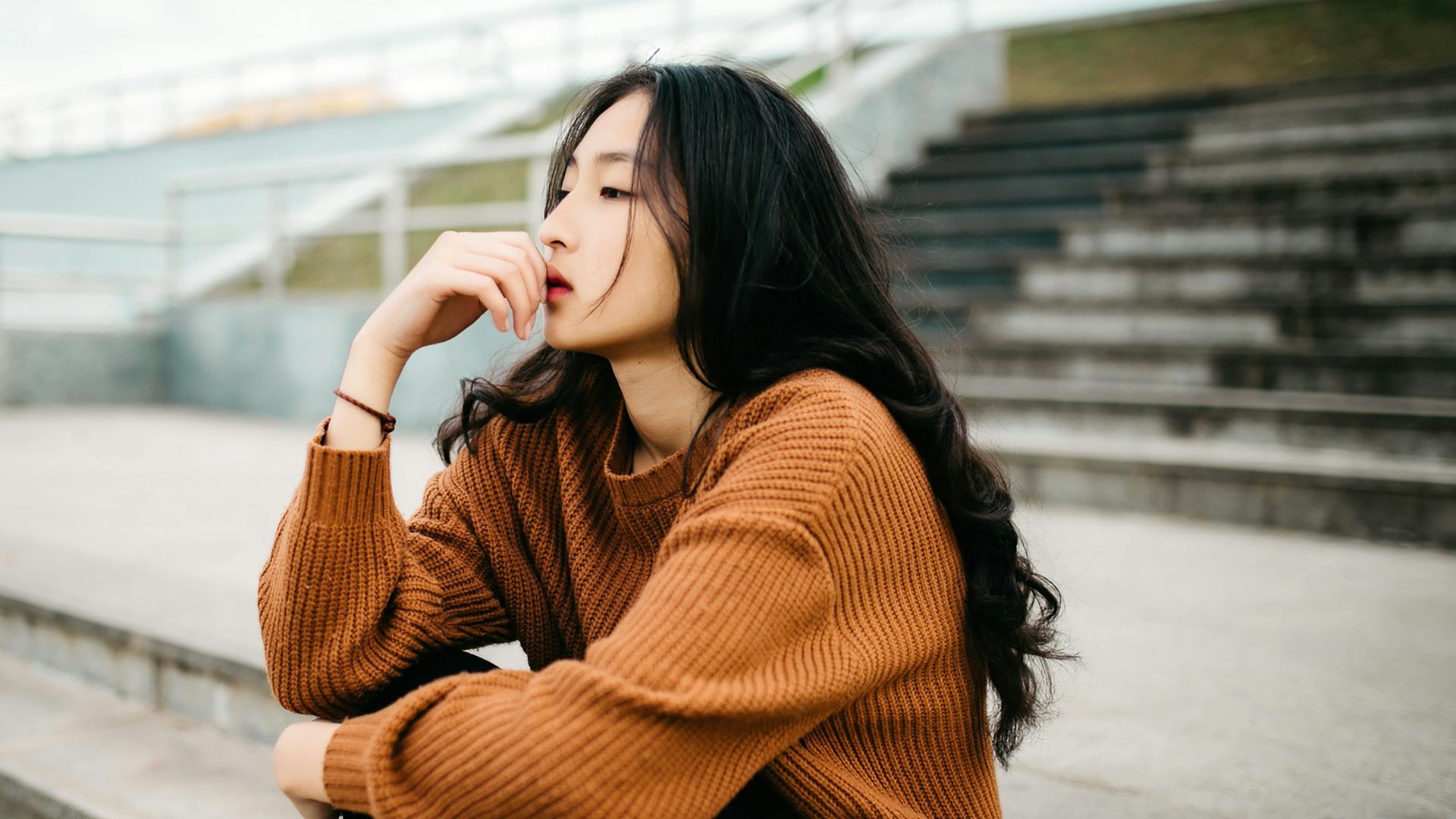 woman wearing brown sweater holding lips